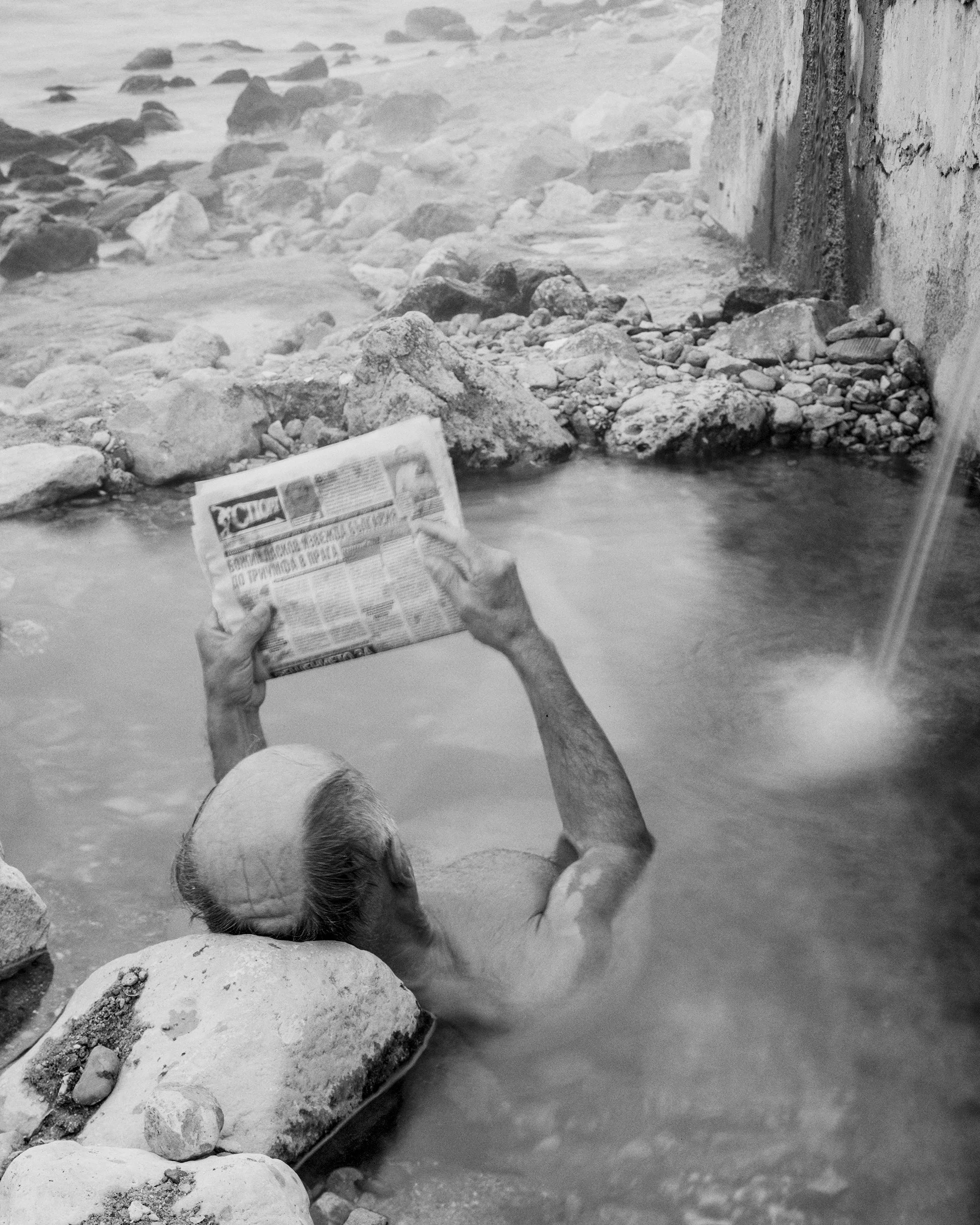 "Man reading the sport news from the series The Hot Waters - Varna, Bulgaria 2023" - Christo Stankulov, Gelatin silver print on Fomabrom baryta paper, 12" x 16", $1,850