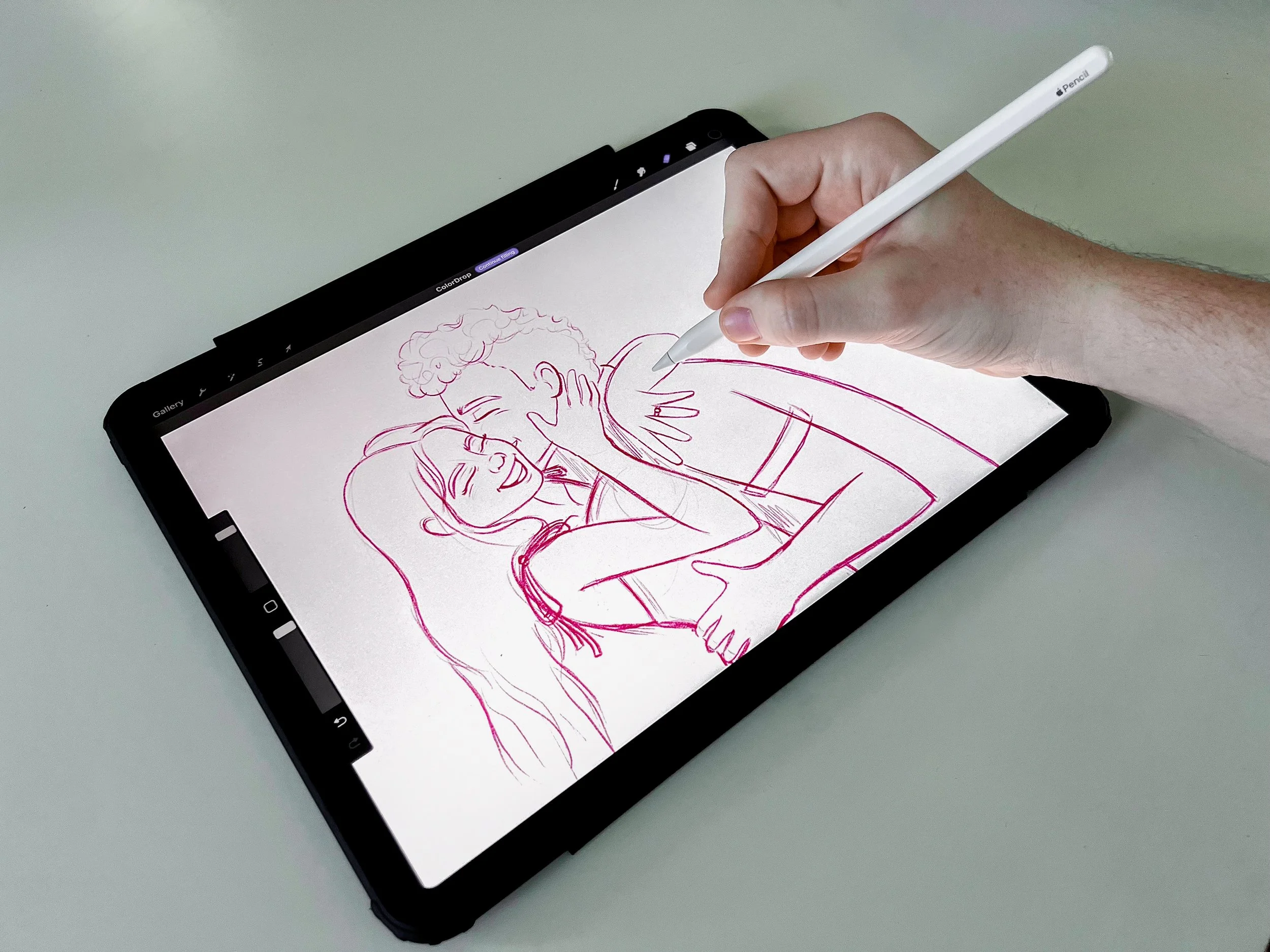 Berlynn Burns from the Burns Creative is using an Apple Pencil on a tablet to create a digital drawing illustration of a couple kissing.