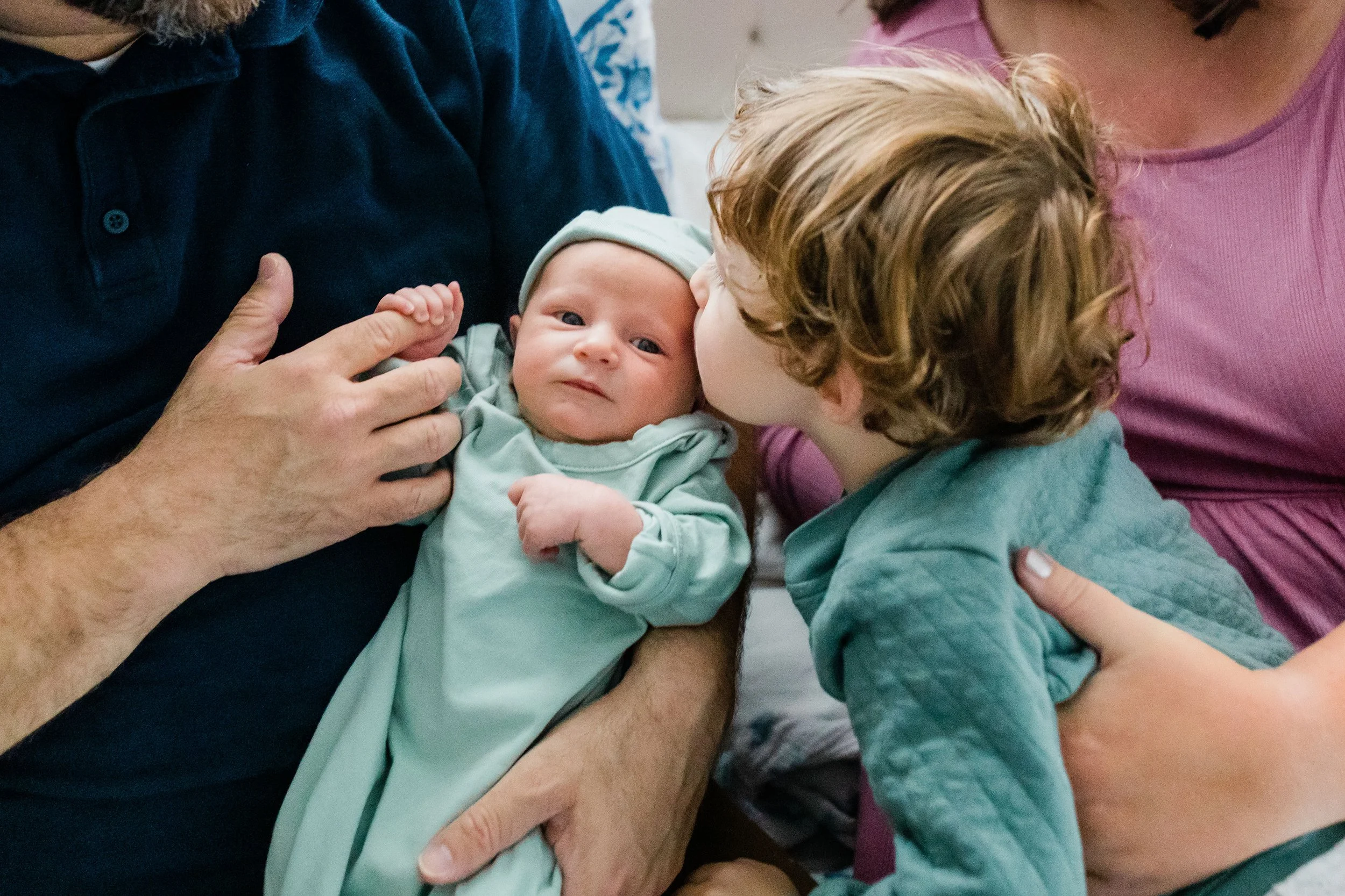 newborn baby with mom and dad indoors, taken by outdoor family photographer in Northern Virginia