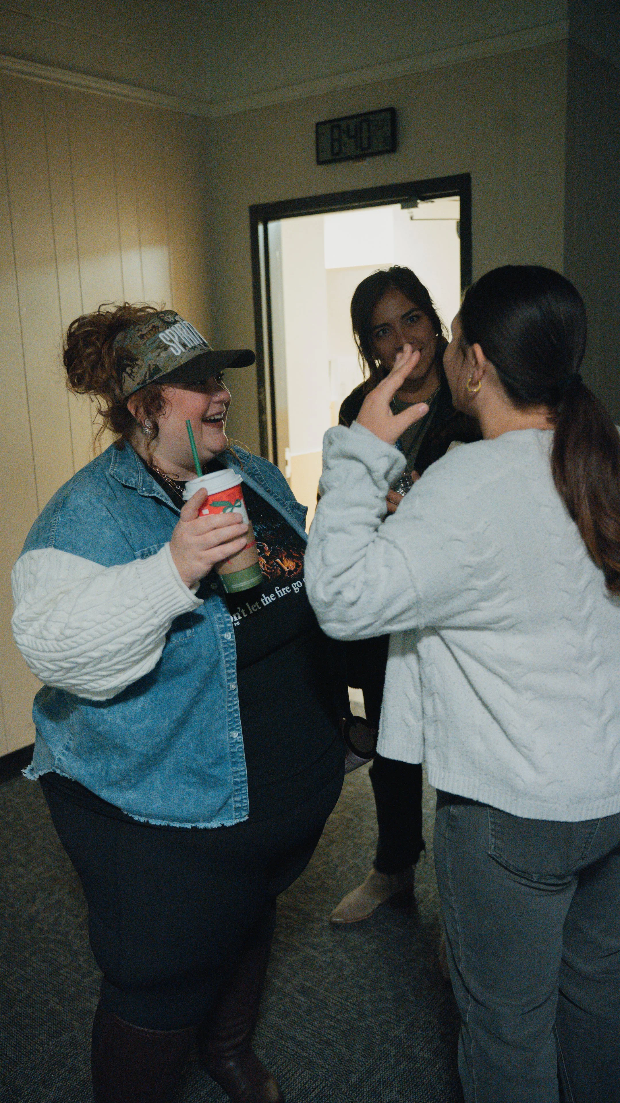 Three women are having a conversation smiling.
