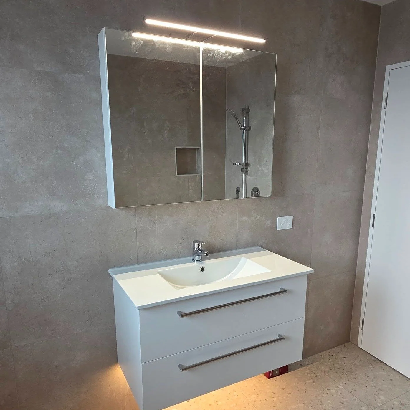 Layered lighting makes such a huge difference to both the feel and utility of a room. This bathroom has three layers,
- The downlights, great for filling the whole room with light
- The mirror light, essential for lighting up your face when applying 