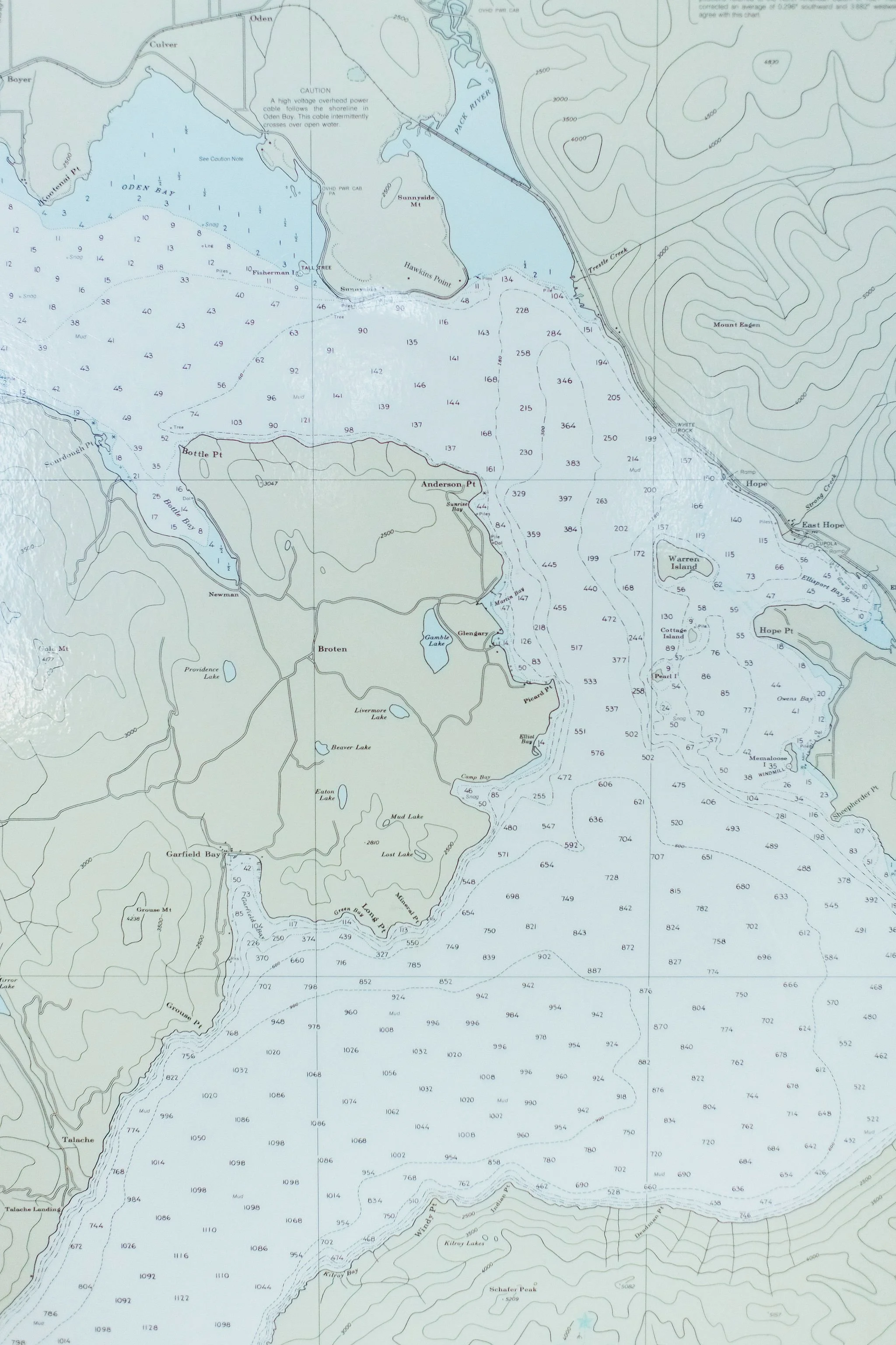 A detailed topographic map of a lake with surrounding terrain, including various islands, peninsulas, and water depths marked with numbers. The map shows contour lines indicating elevation changes, labels for geographic features like hawkins point, Warren island, and various lakes, with roads and trails depicted.