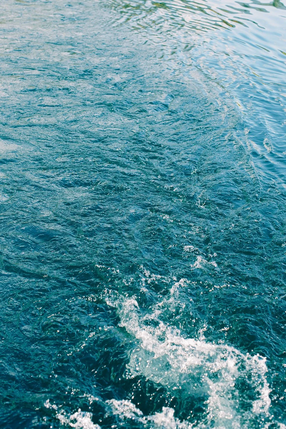 A view of the ocean showing the wake left by a boat, with ripples and waves on the water surface.