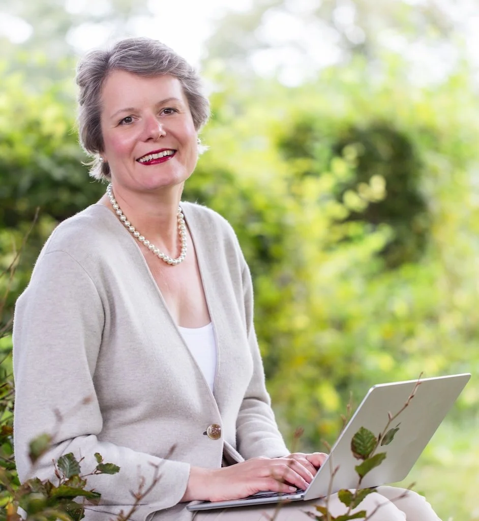 Lydia Böhm, Finanz-Mentorin aus Hamburg, am Laptop im Garten