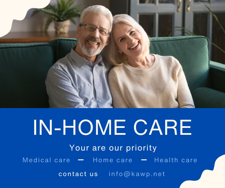 Smiling elderly man and woman sitting on a green couch in a living room.