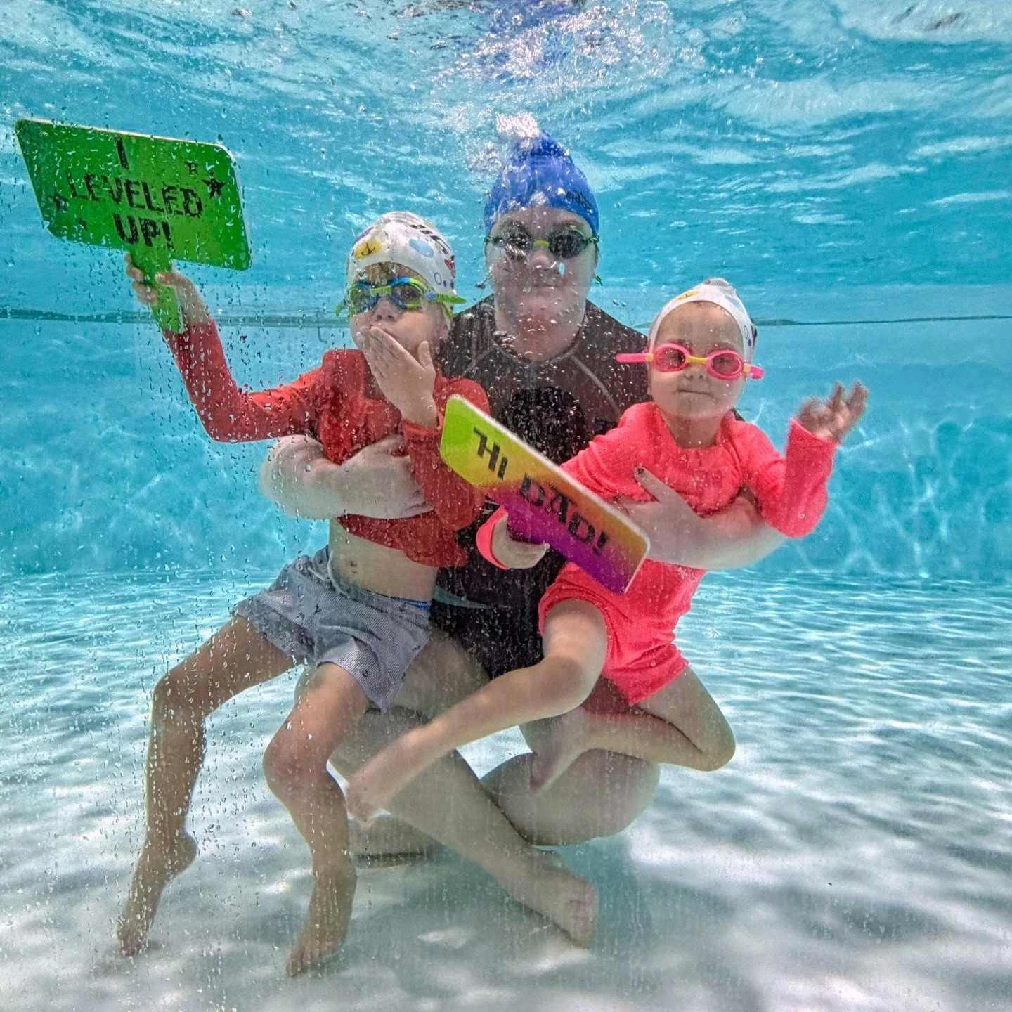 👋📸 Milestones and moments&mdash;captured underwater.

One proud &ldquo;I Leveled Up!&rdquo; (with a kiss 💋) and one sweet &ldquo;Hi Dad!&rdquo;&mdash;all in the same splash. These through-the-glass moments remind us that progress, pride, and conne