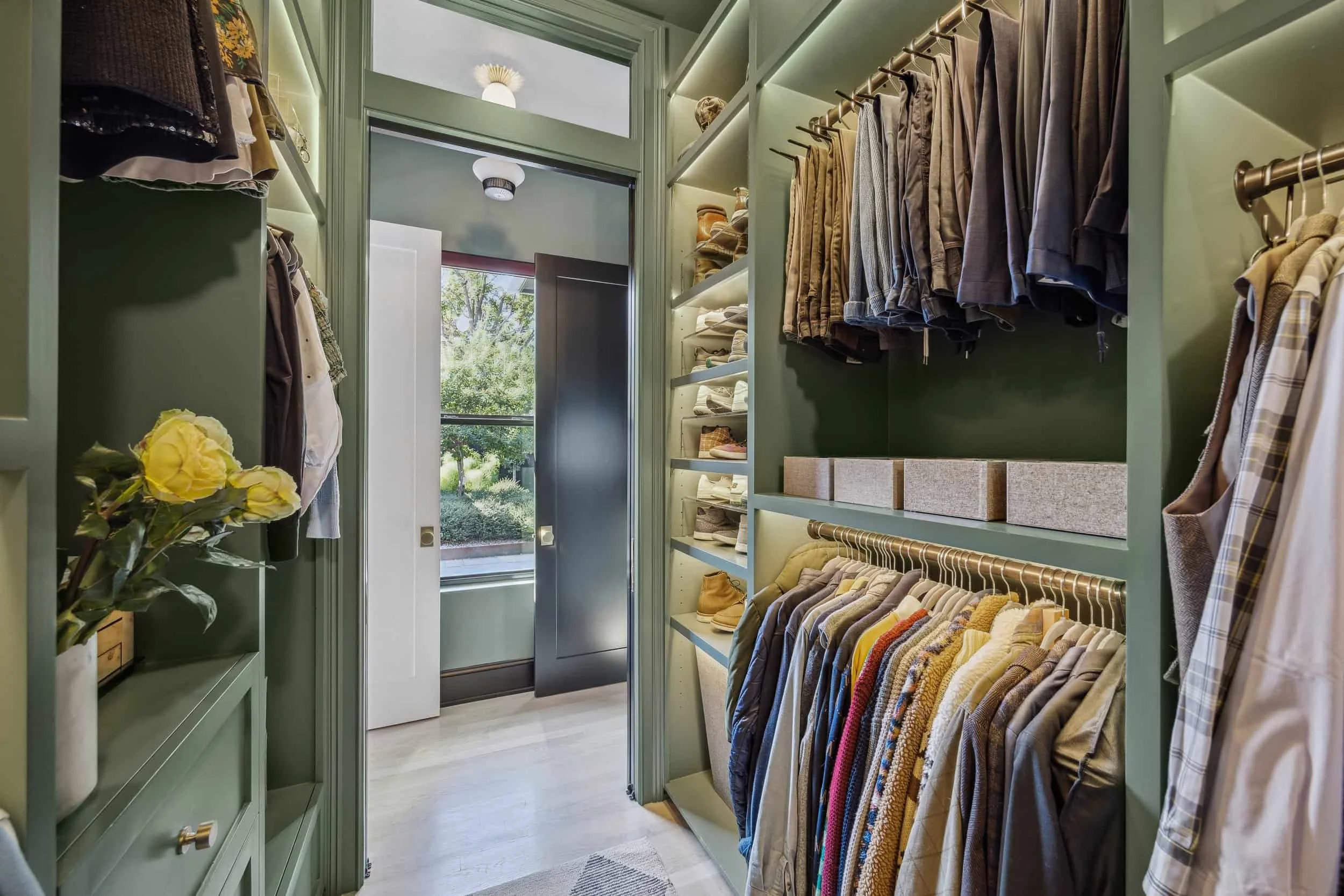 BOUTIQUE-STYLE PRIMARY CLOSET  Part of a full primary suite renovation for a growing Houston family, this his-and-hers closet was planned around two very different daily routines.  