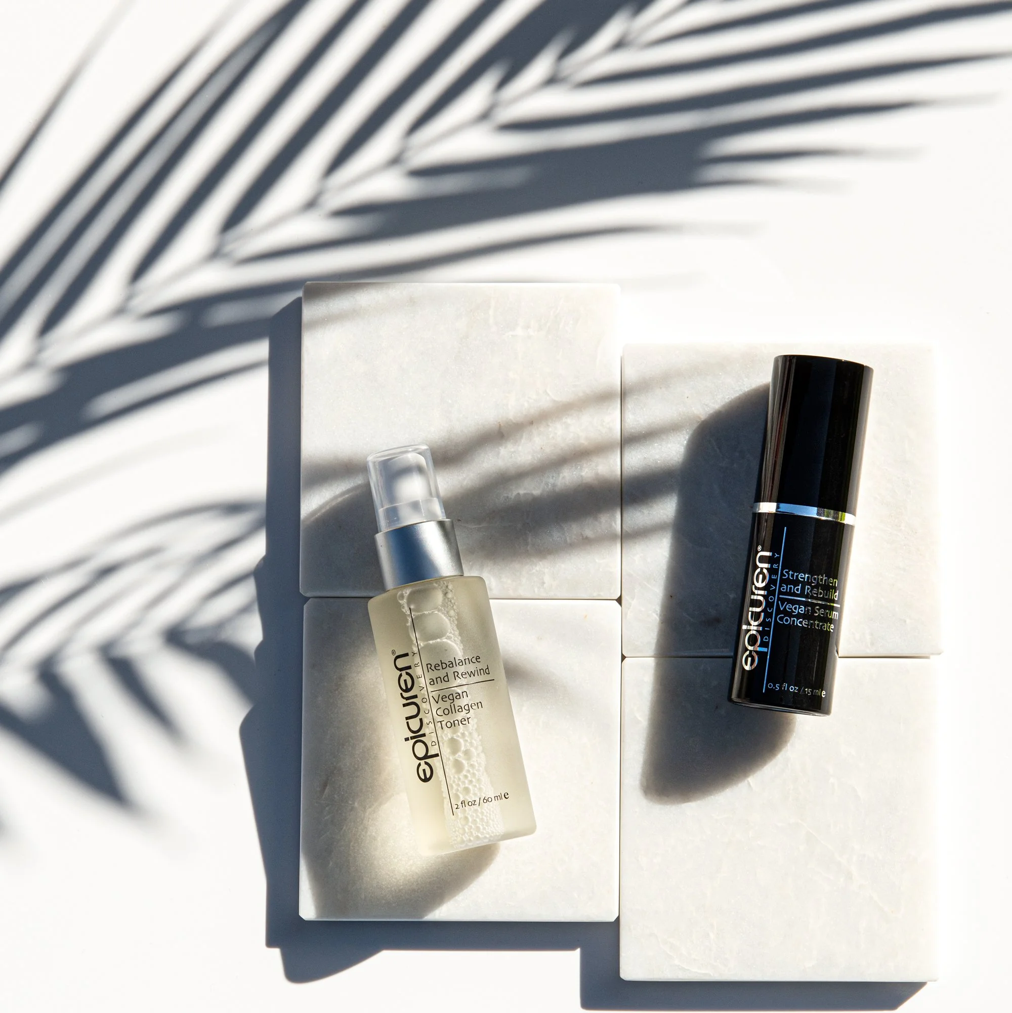 Skincare products on white tiles with shadow of palm leaves