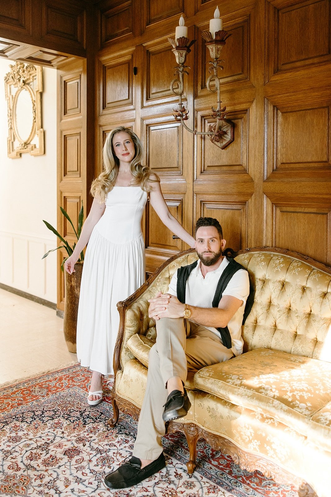 couple for engagement shoot posing in the intricate wood hallway of the etienne estate