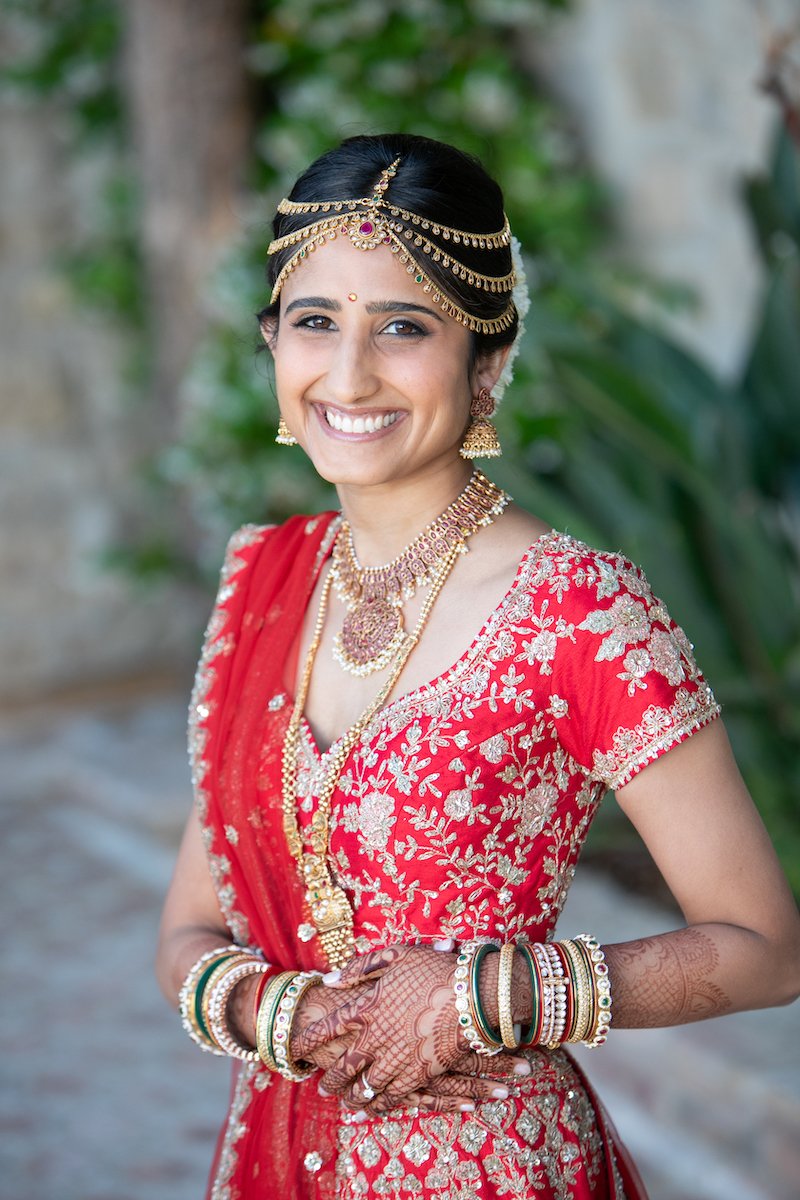 South Asian Updo Bridal Hairstyle with Tikka and traditional jewelry