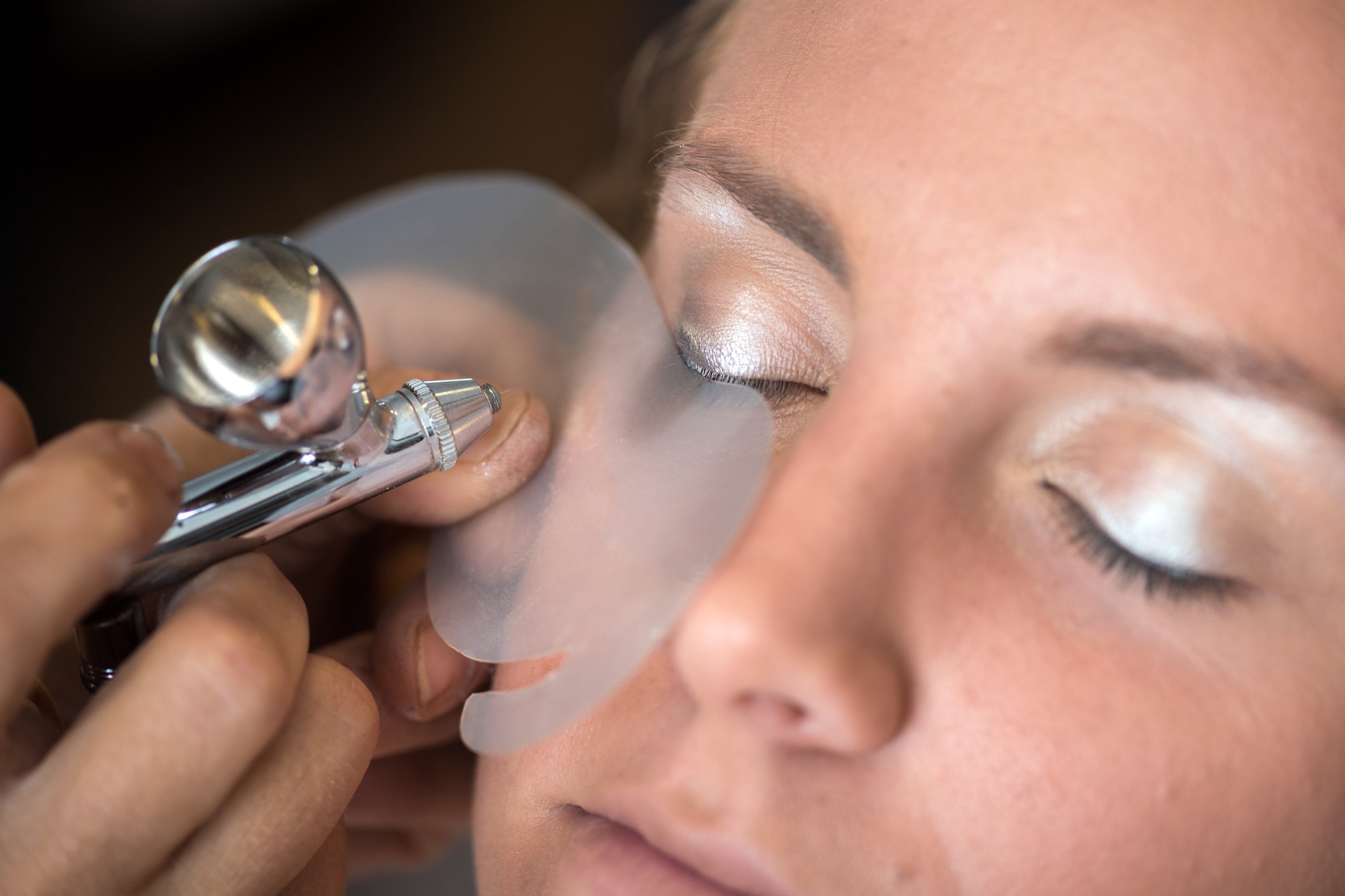 artist airbrushing eyeshadow onto client