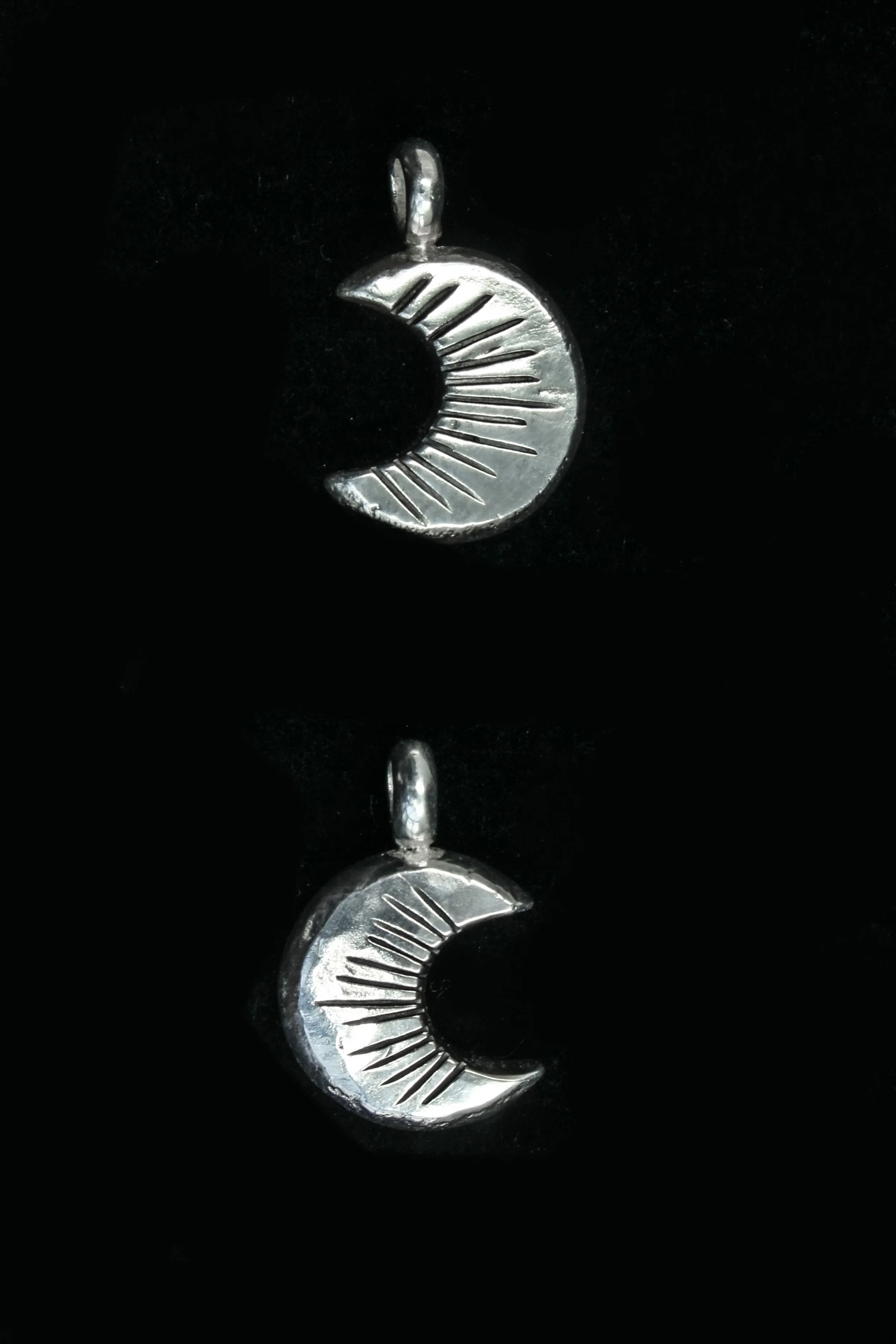 Image showing two Laussel moon designs on a black background, one waxing crescent and one waning, each bearing thirteen notches