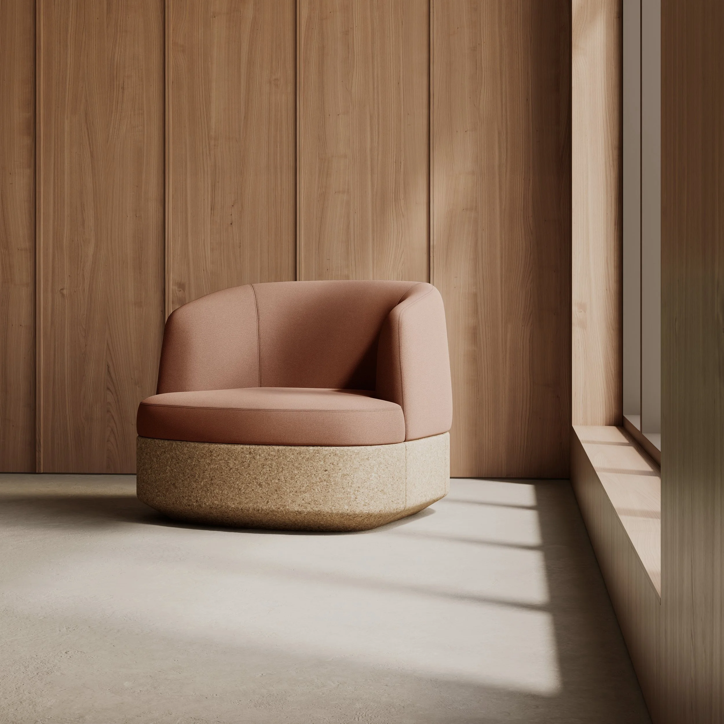 A modern, pink upholstered chair with a rounded base in a room with wood-paneled walls and sunlight streaming in through a window.