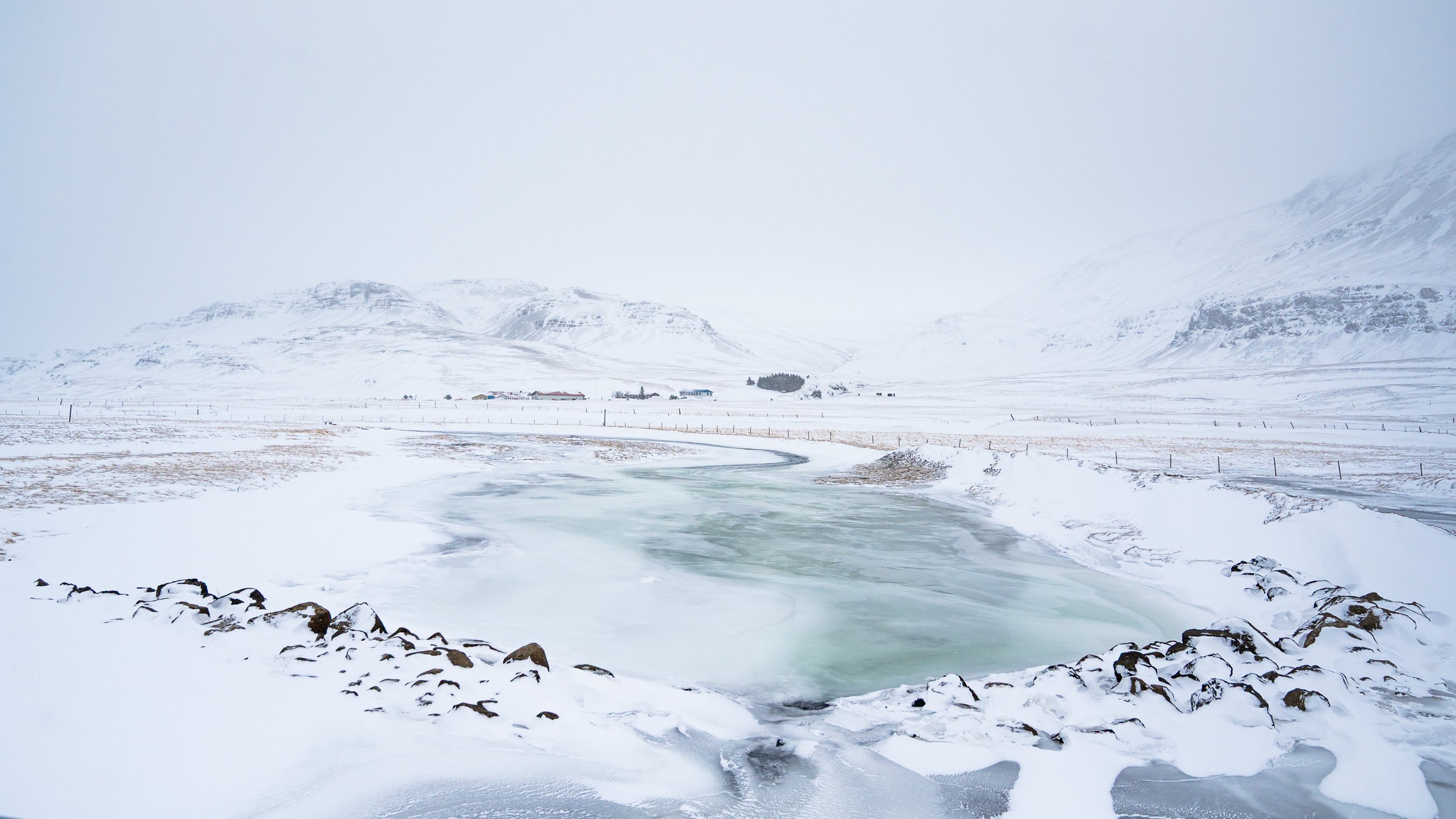 Paysage de neige minimaliste où le sol et le ciel se confondent dans un dégradé de blanc et de gris, série Immersion.