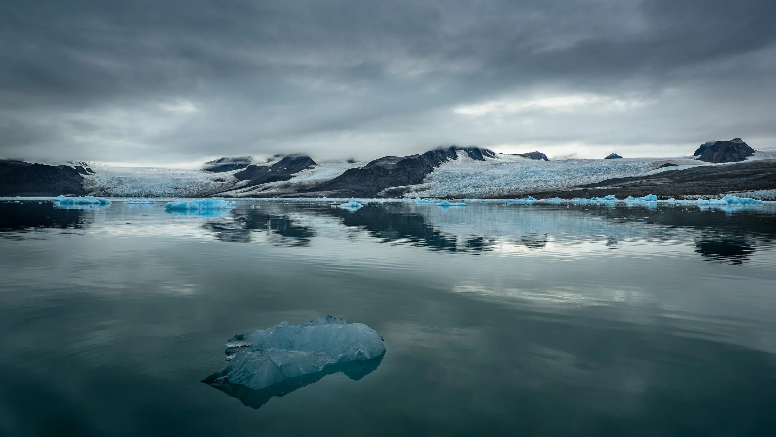 Blocs de glace d'un bleu pur flottant sur les eaux calmes d'une lagune glaciaire, photographie de nature minimaliste. Spitsberg

