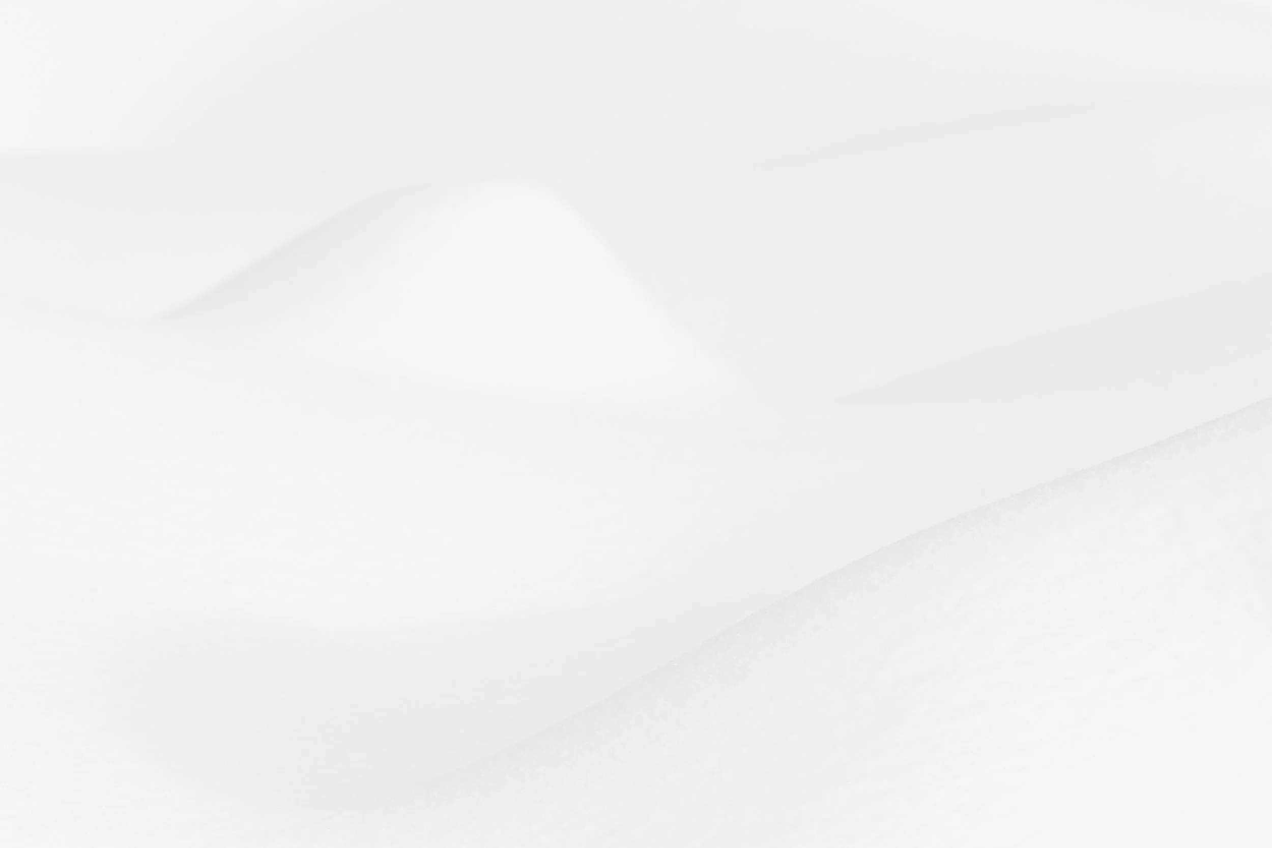 Gros plan sur une petite butte de neige isolée au milieu d'un paysage blanc minimaliste