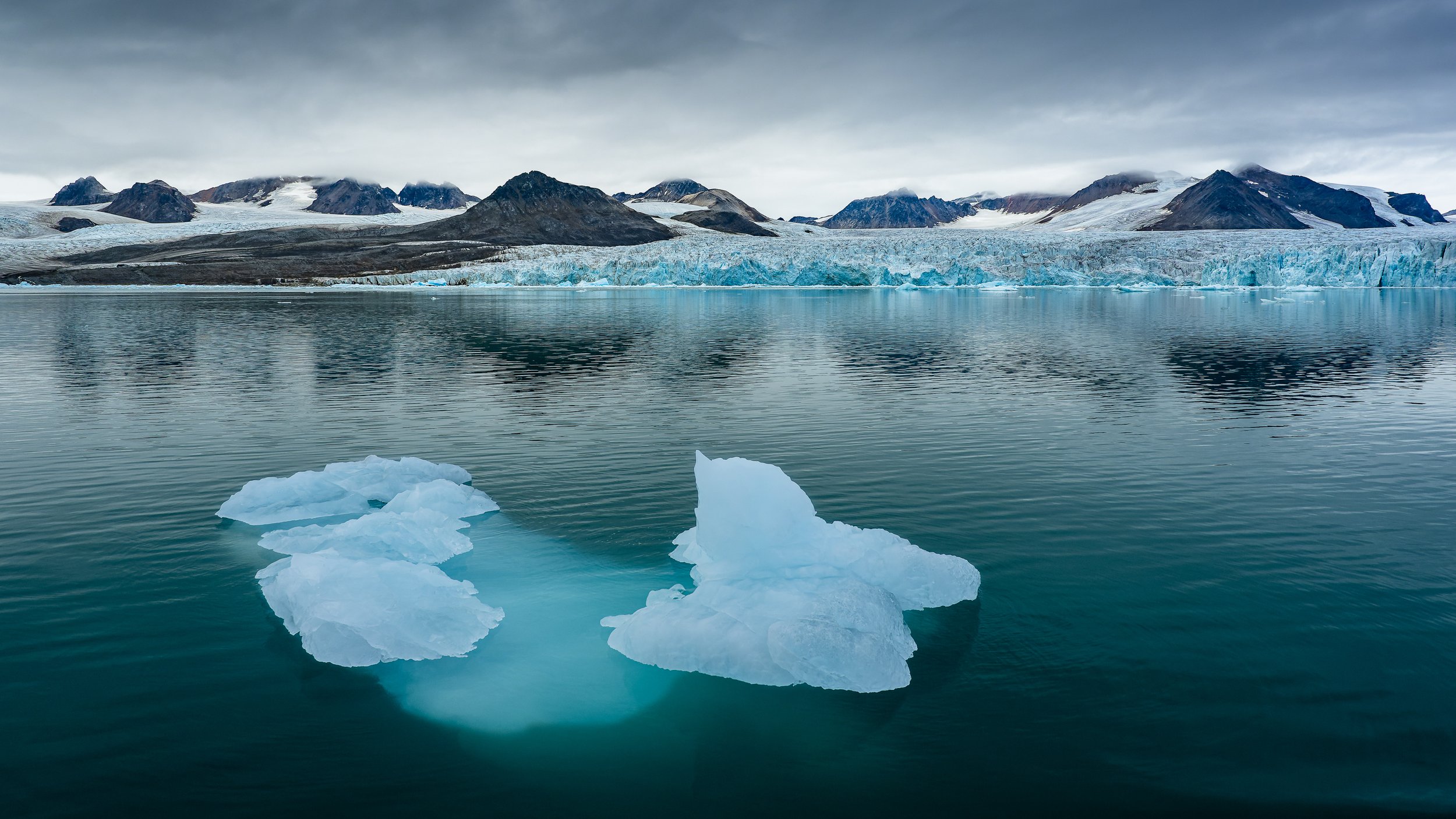 	Horizon où se confondent l'eau, la glace et le ciel gris, photographie d'art invitant à la contemplation.