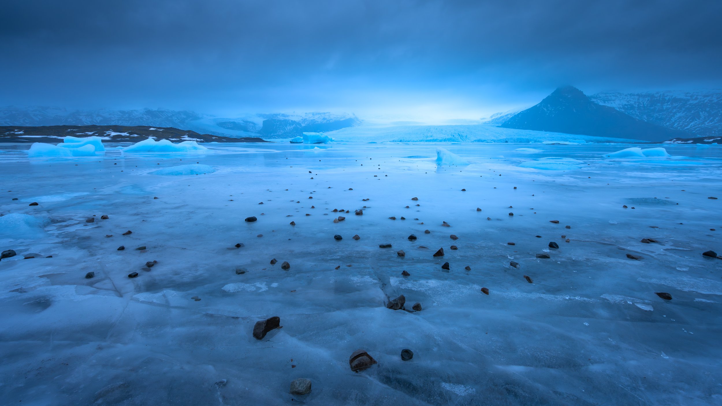 	Immensité d'une plaine de glace sous une lumière crépusculaire bleutée, perspective épurée sur le Grand Nord.