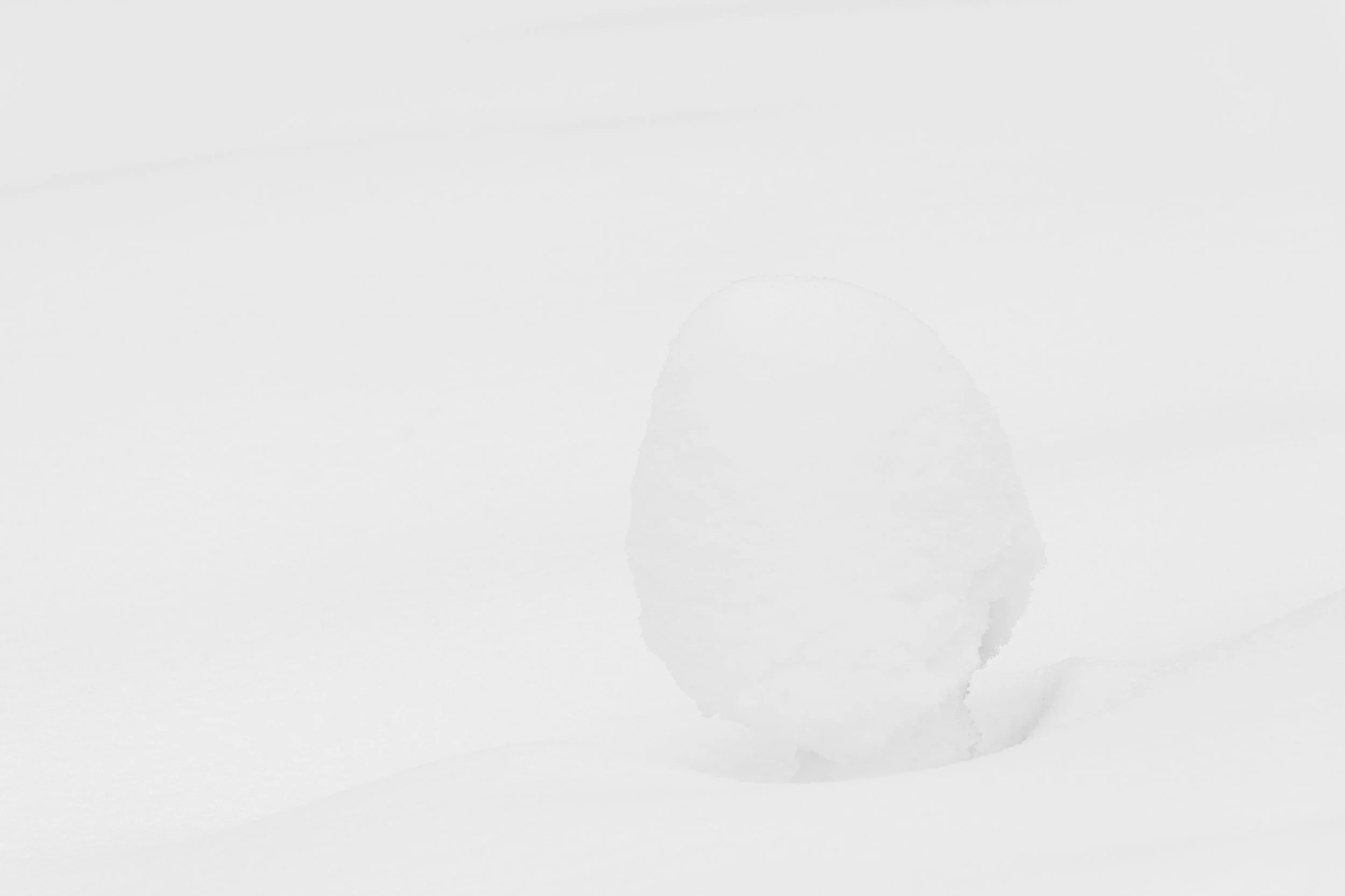 ovoïde de neige se détachant légèrement par un jeu d'ombre délicat dans un décor monochrome. Minimalisme
