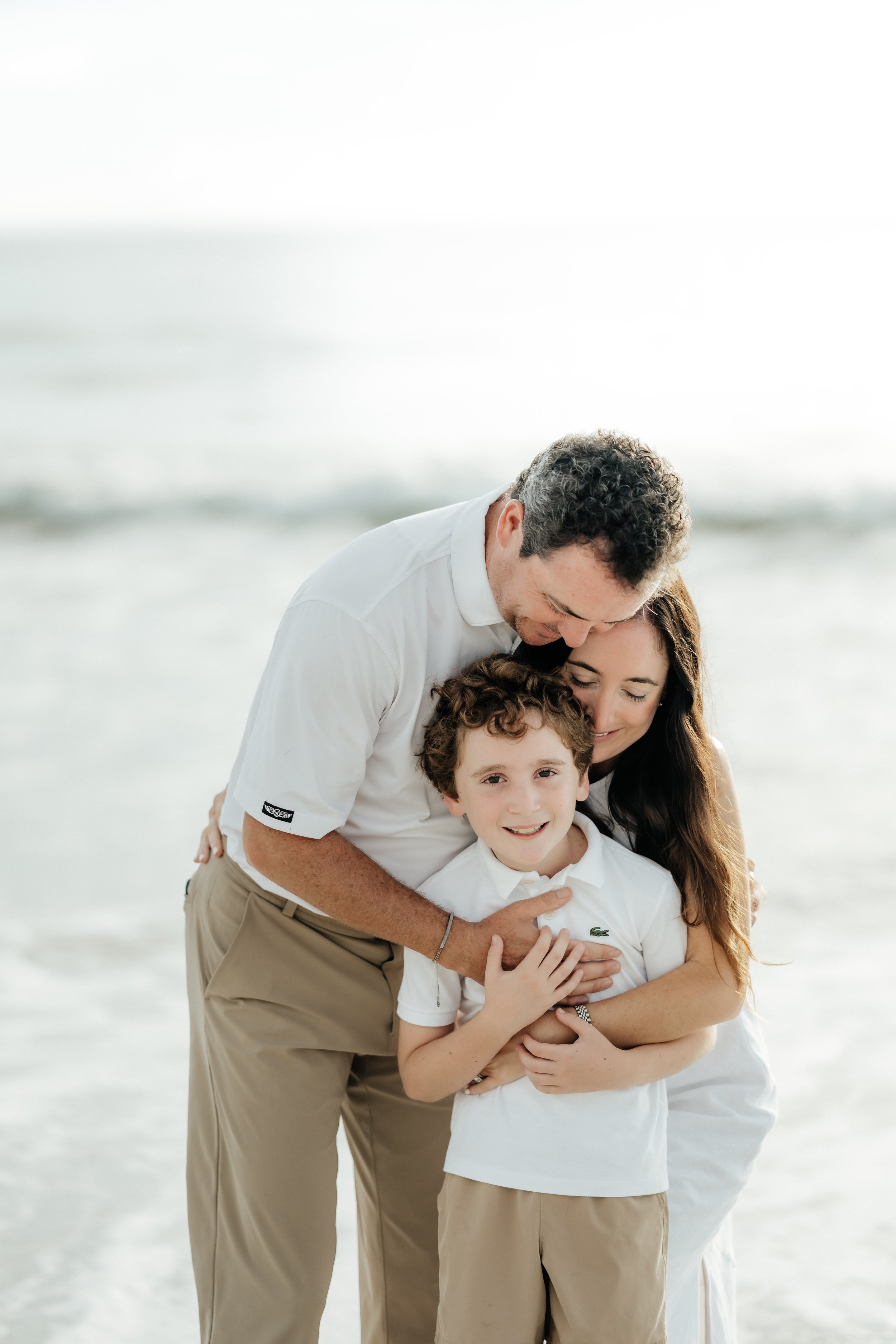 Family of 3 on the beach at sunrise in jacksonville florida shot by Hailee Cataldi photo