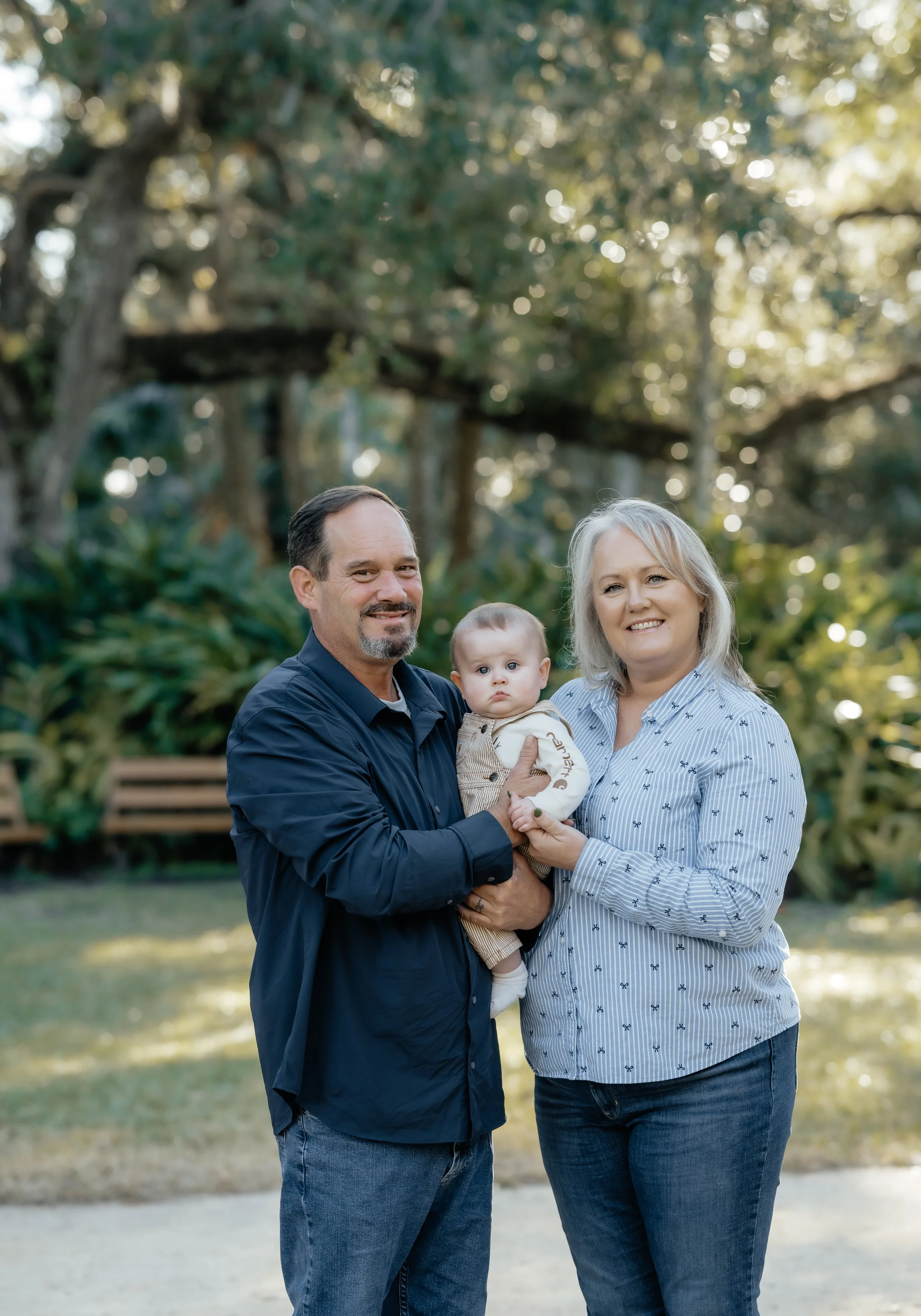 grandma and grandpa with their grandchild at Washington oaks park in palm coast florida shot by hailee Cataldi photo