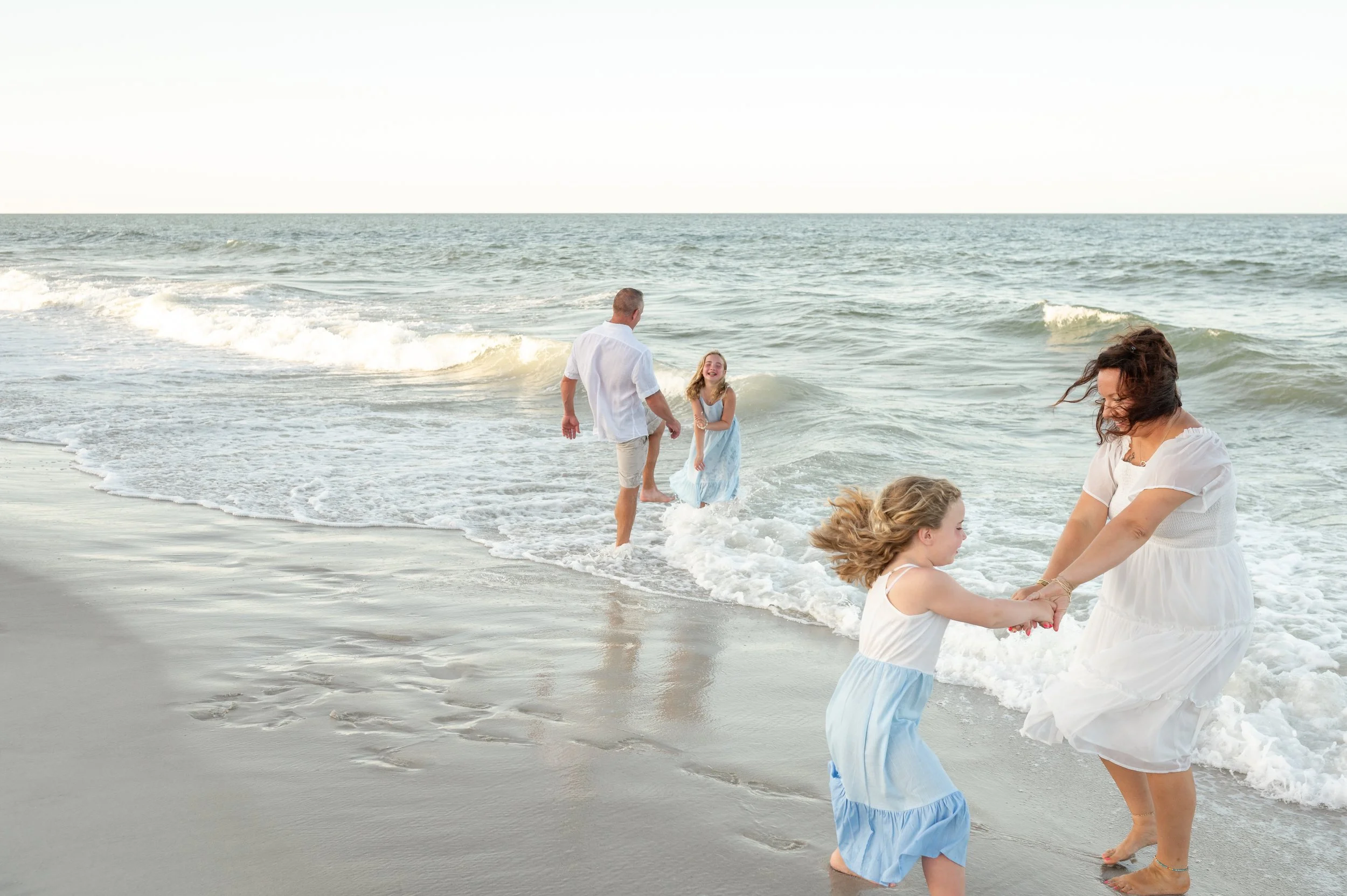 a family dancing in the waves at the beach in jacksonville florida
