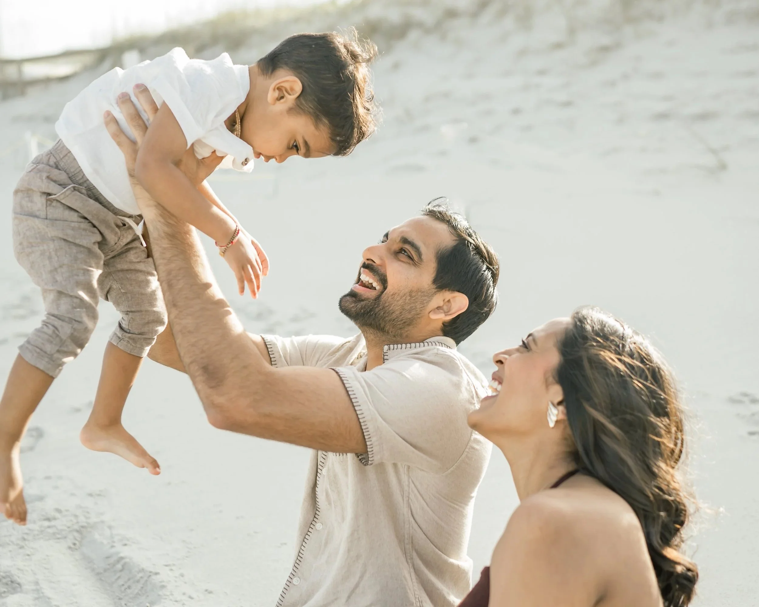 parents with their child playing on the beach in jacksonville florida