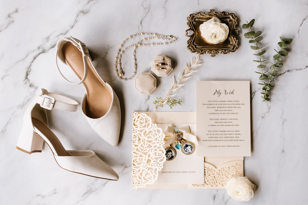  Wedding detail flatlay of a bride’s shoes, jewelry, invitations, and more 