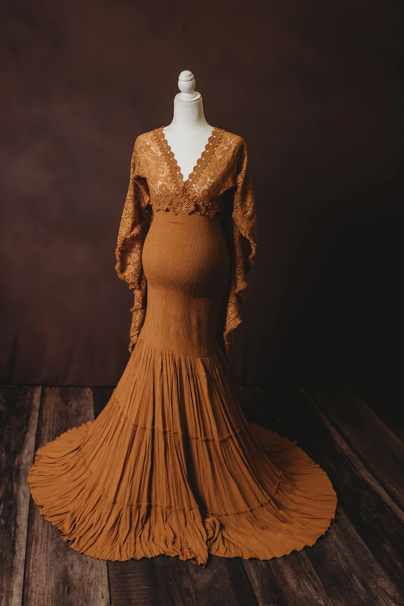 Rust-colored maternity gown on mannequin with lace details