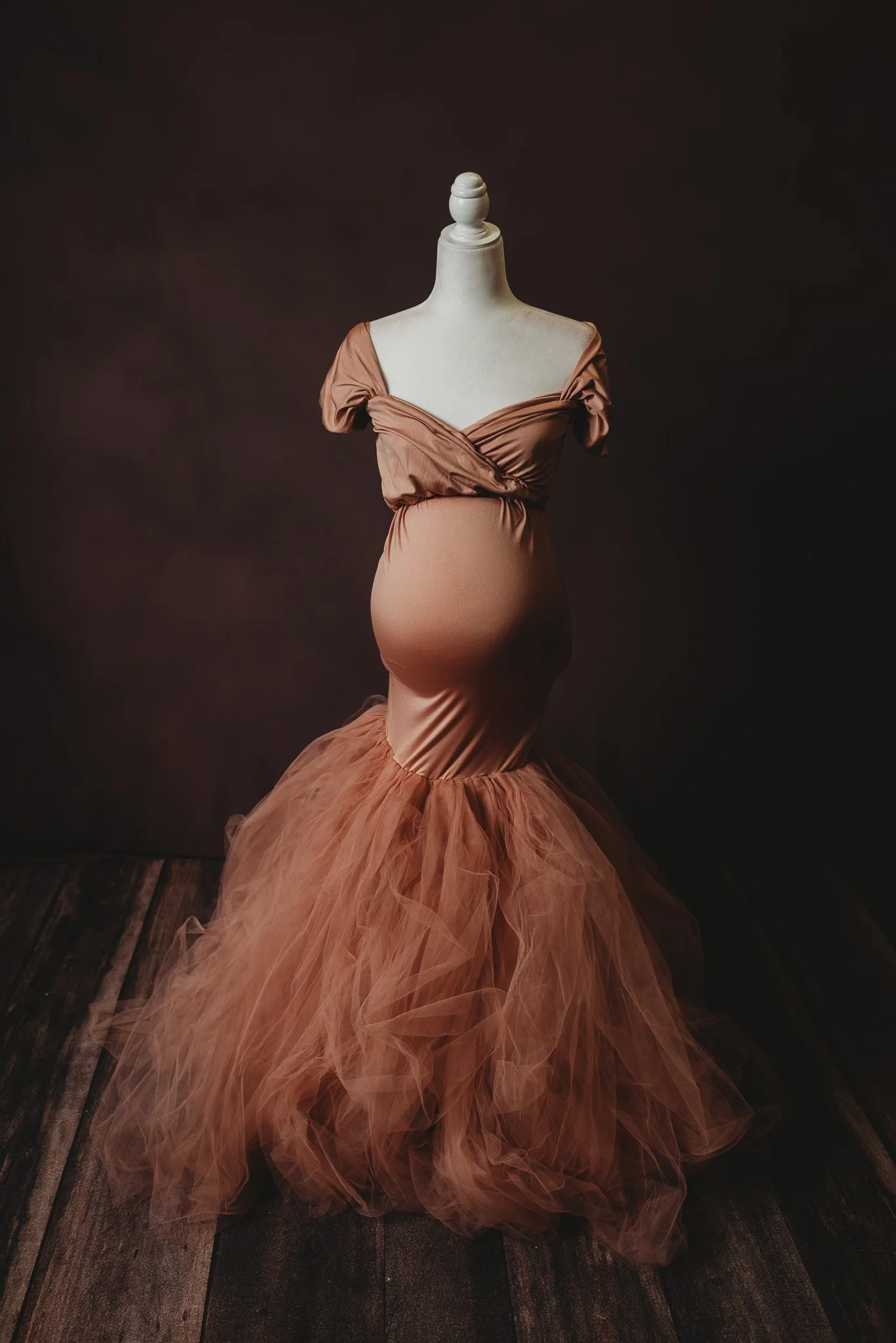 Mannequin wearing a brown maternity gown with a tulle skirt.