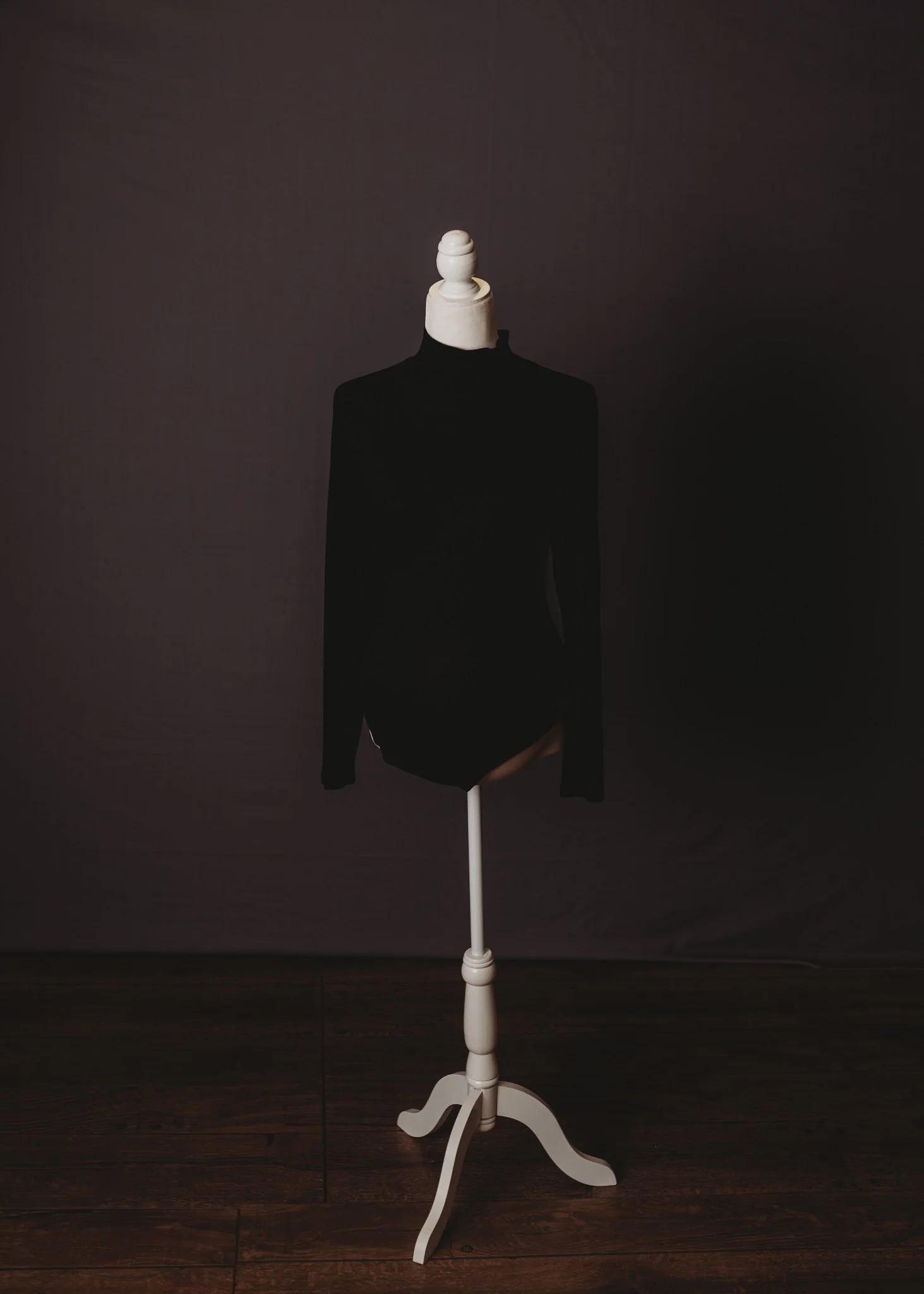 Black bodysuit on a mannequin in a dark room