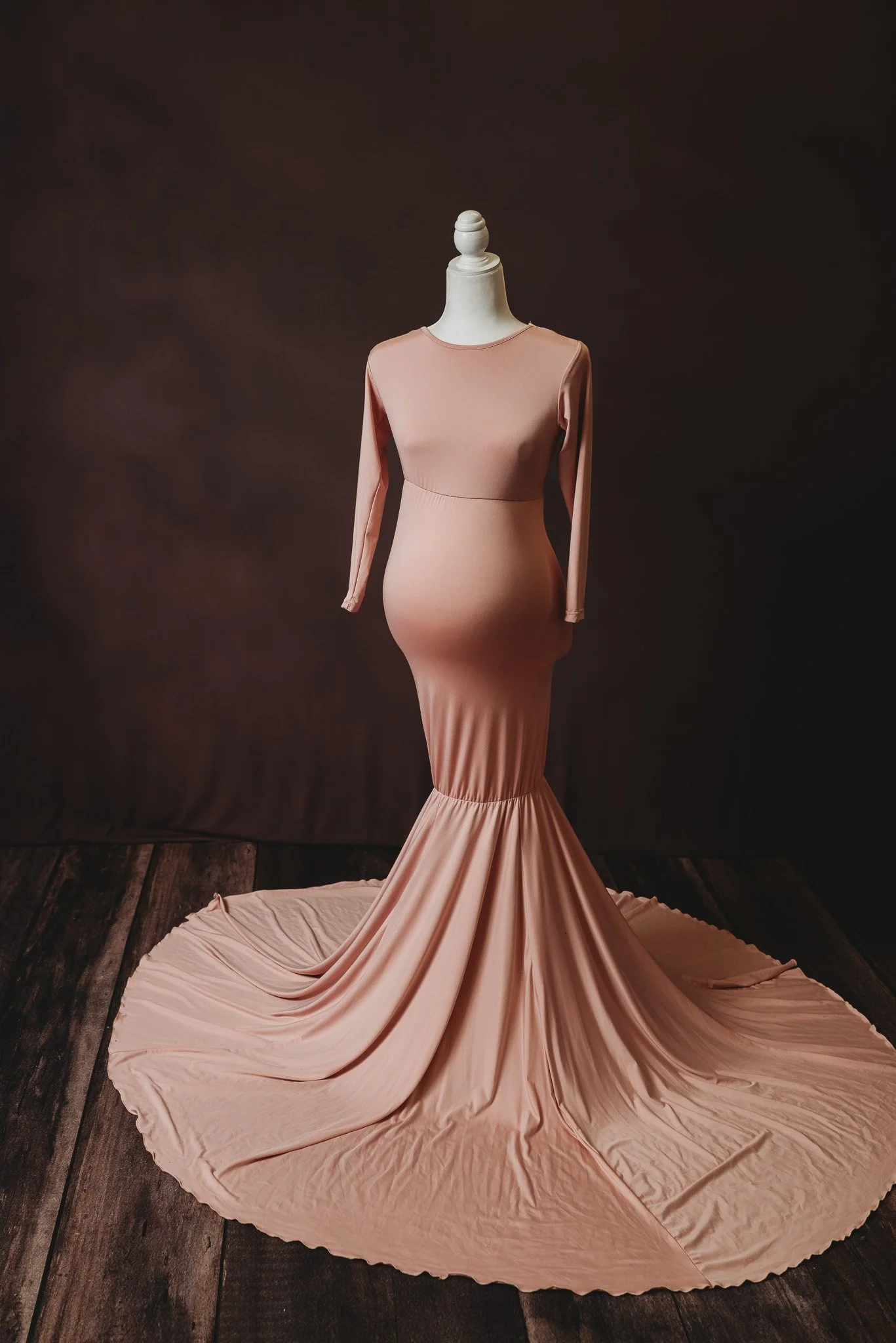 Maternity dress on mannequin with beige long sleeves and flowing train.