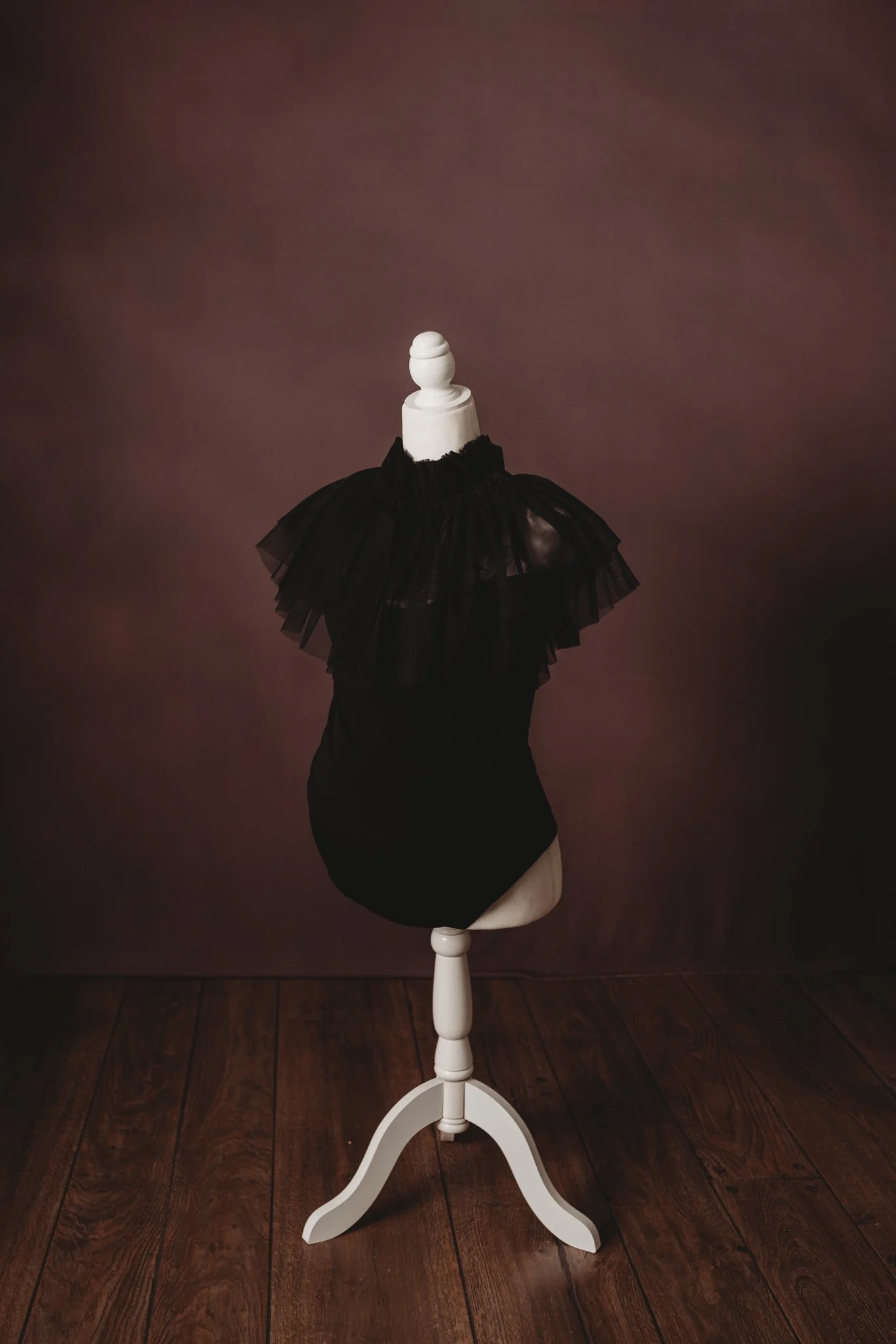 mannequin with black tulle cape on wooden stand