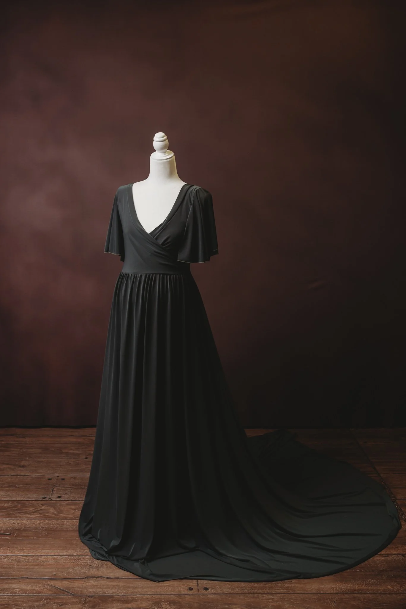 Elegant black dress on mannequin against dark background