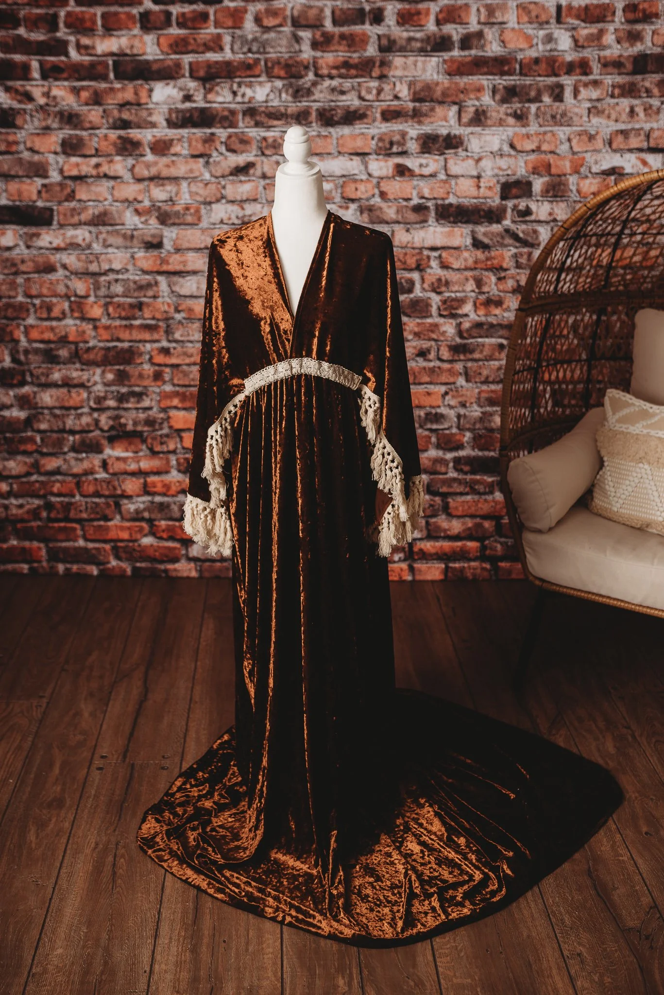 Velvet robe on mannequin with lace details, brick wall background