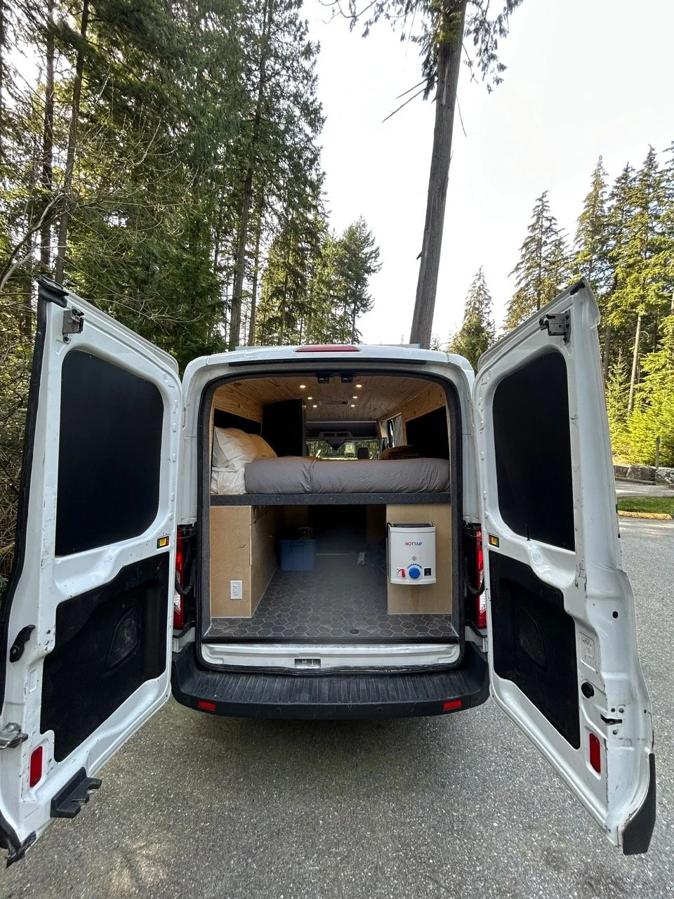 Large storage space in Ford campervan. Parked in British Columbia's forest