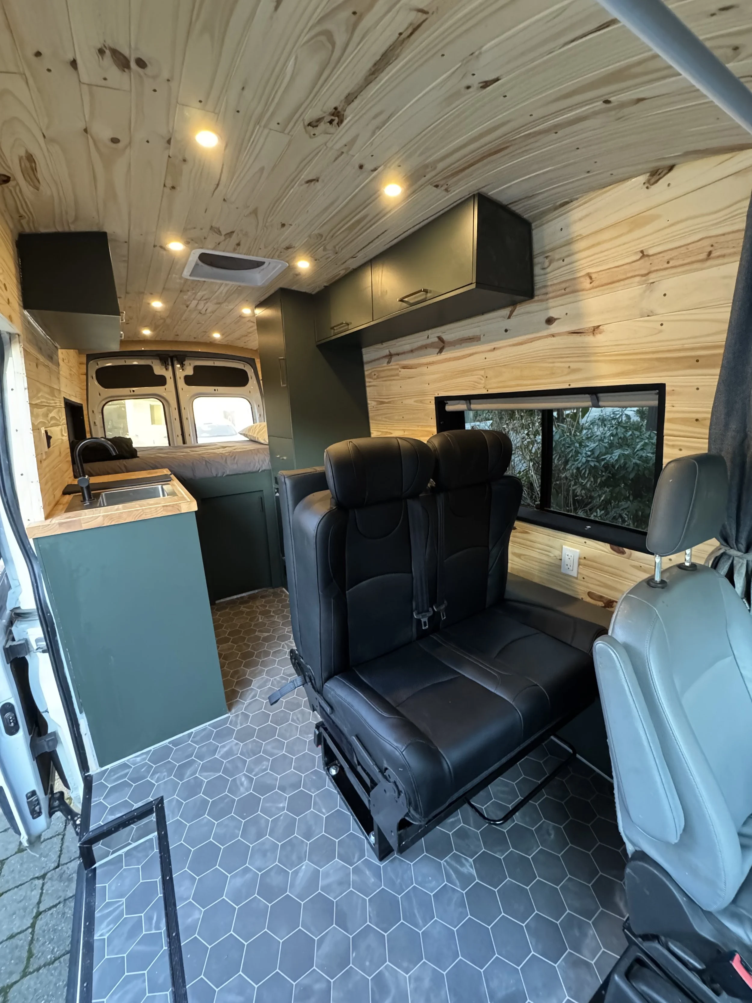 Ford transit campervan that has a foldable bed, cozy pine siding, and luxurious features