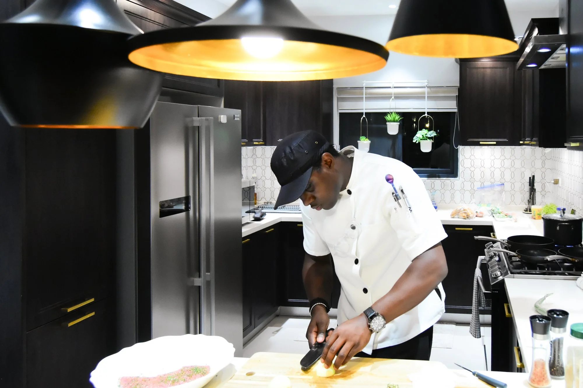 Private chef preparing a gourmet meal in the modern kitchen at Luxe Oasis villa in Ocho Rios, Jamaica, offering guests a personalized in-villa dining experience.