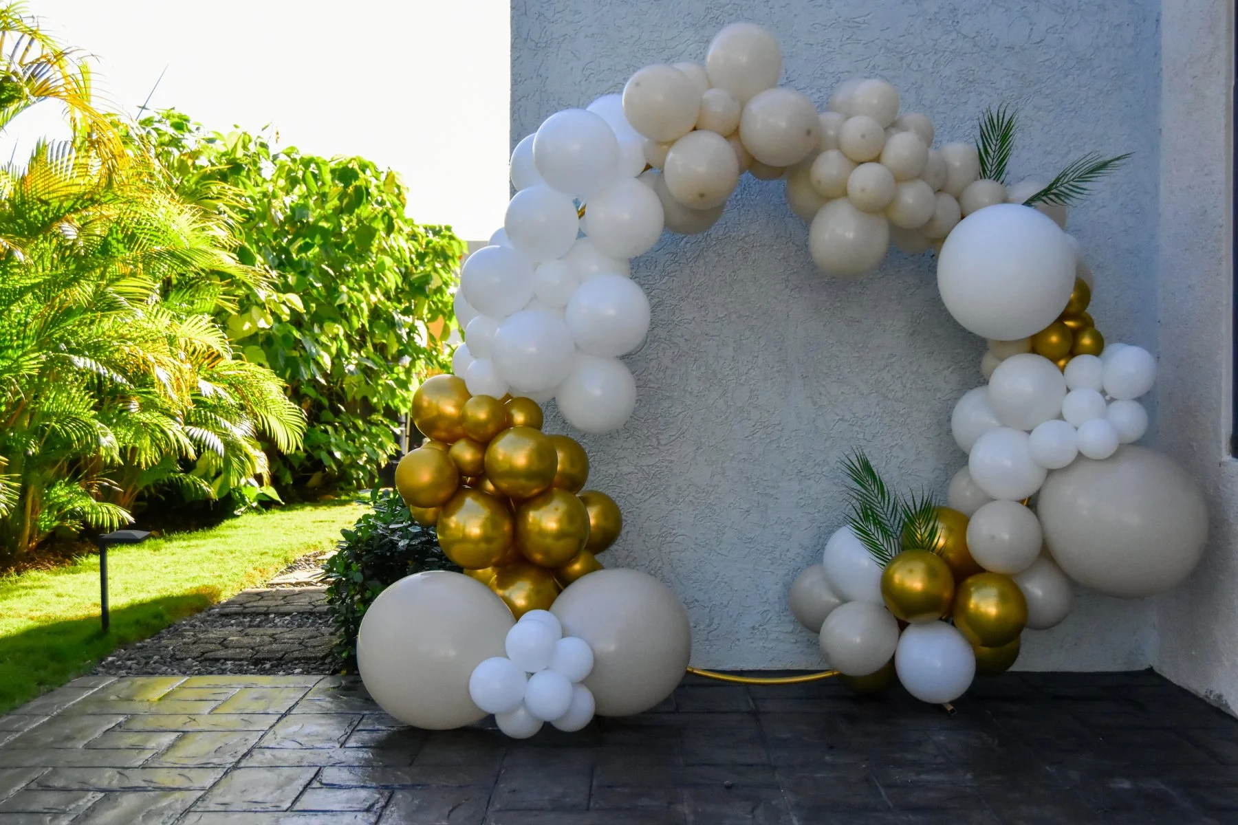 White, champagne and gold birthday balloon display beside the tropical garden at Luxe Oasis in Ocho Rios, Jamaica
