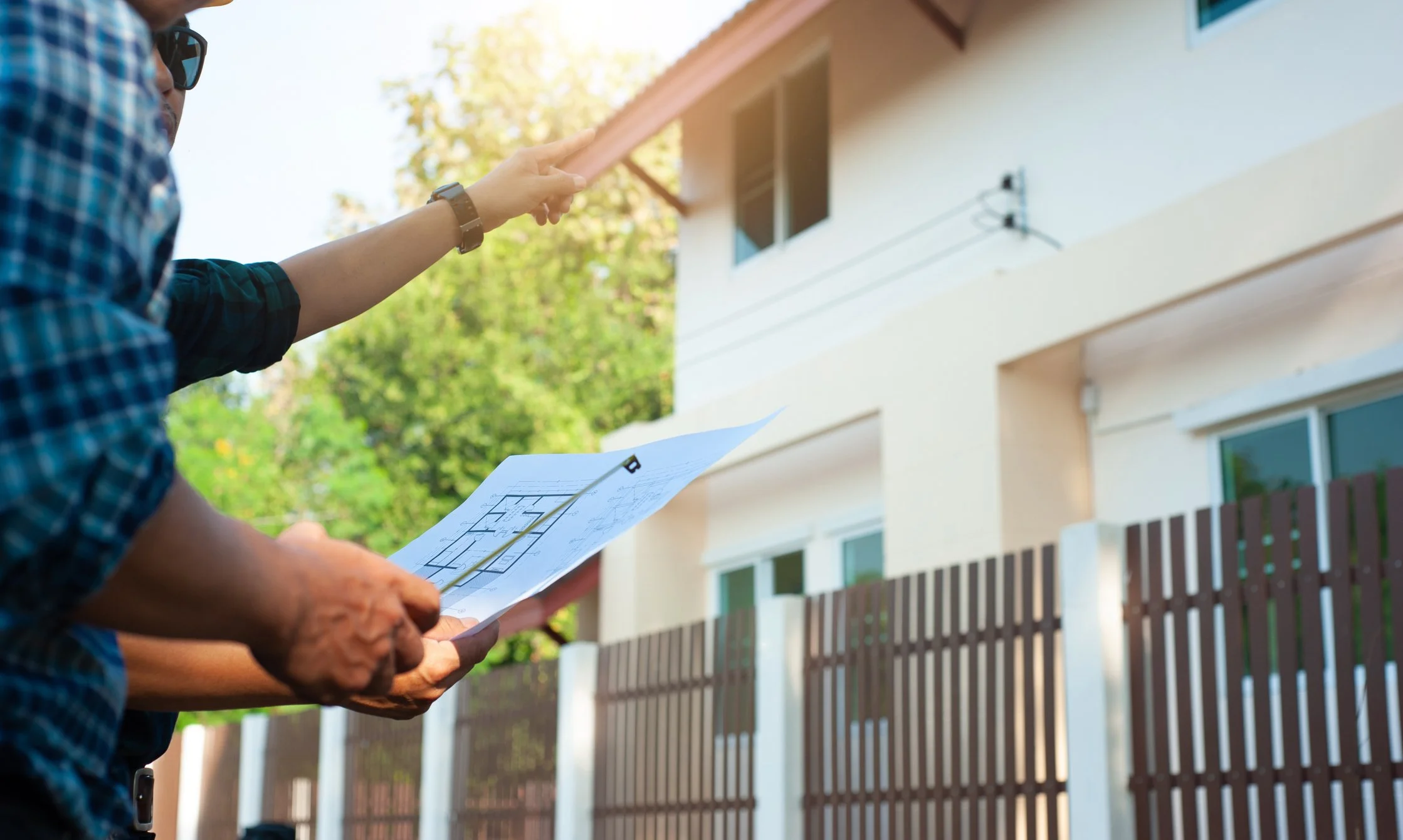 Structural engineer performing a residential structural inspection and reviewing plans outside a home in New Jersey