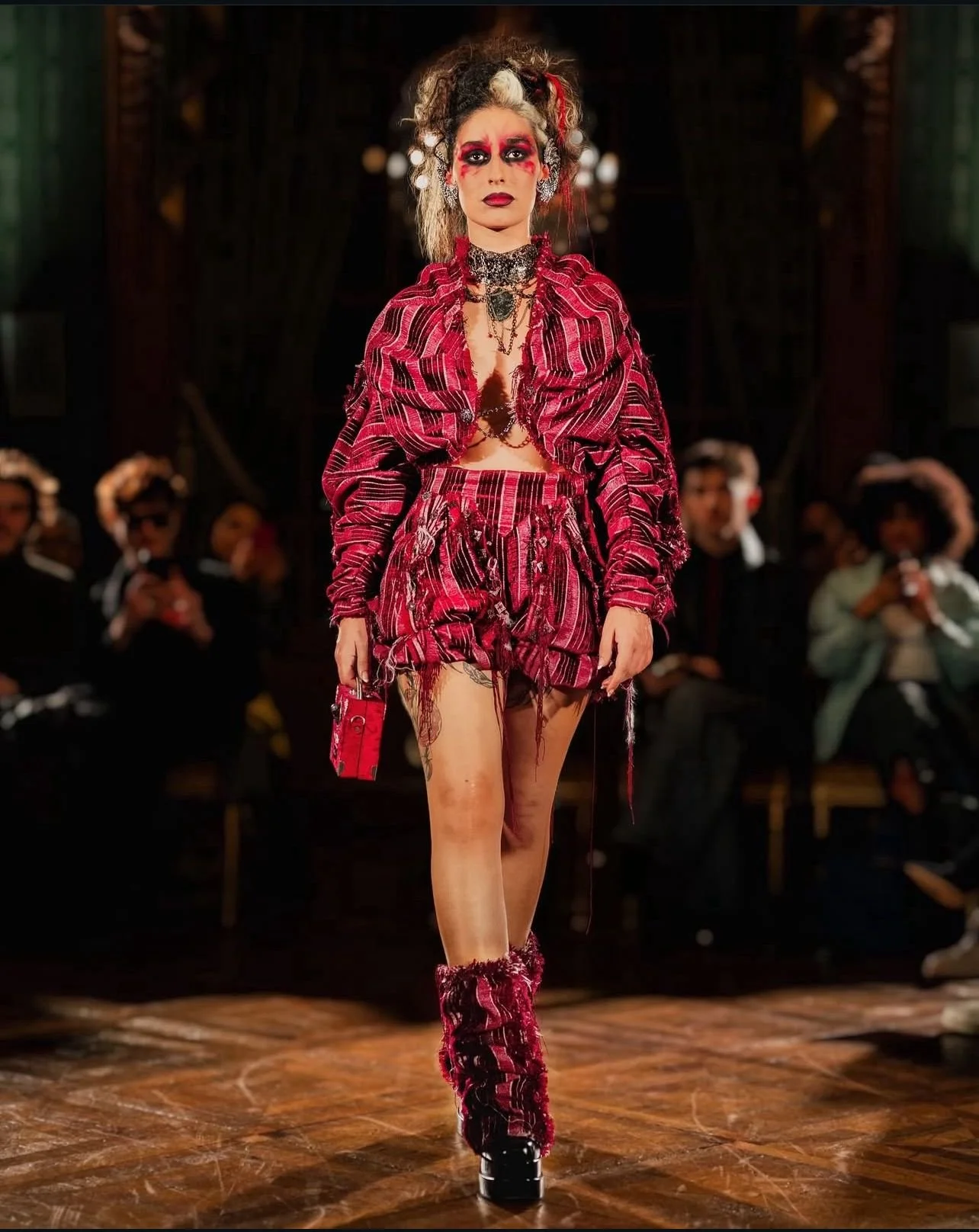 by Noir, Rita Oliveira, walking in Paris Fashion Week for Lorena Couture in 2024 fashion event. Noir is walking in red and black clother, with makeup and hair from fashion week.