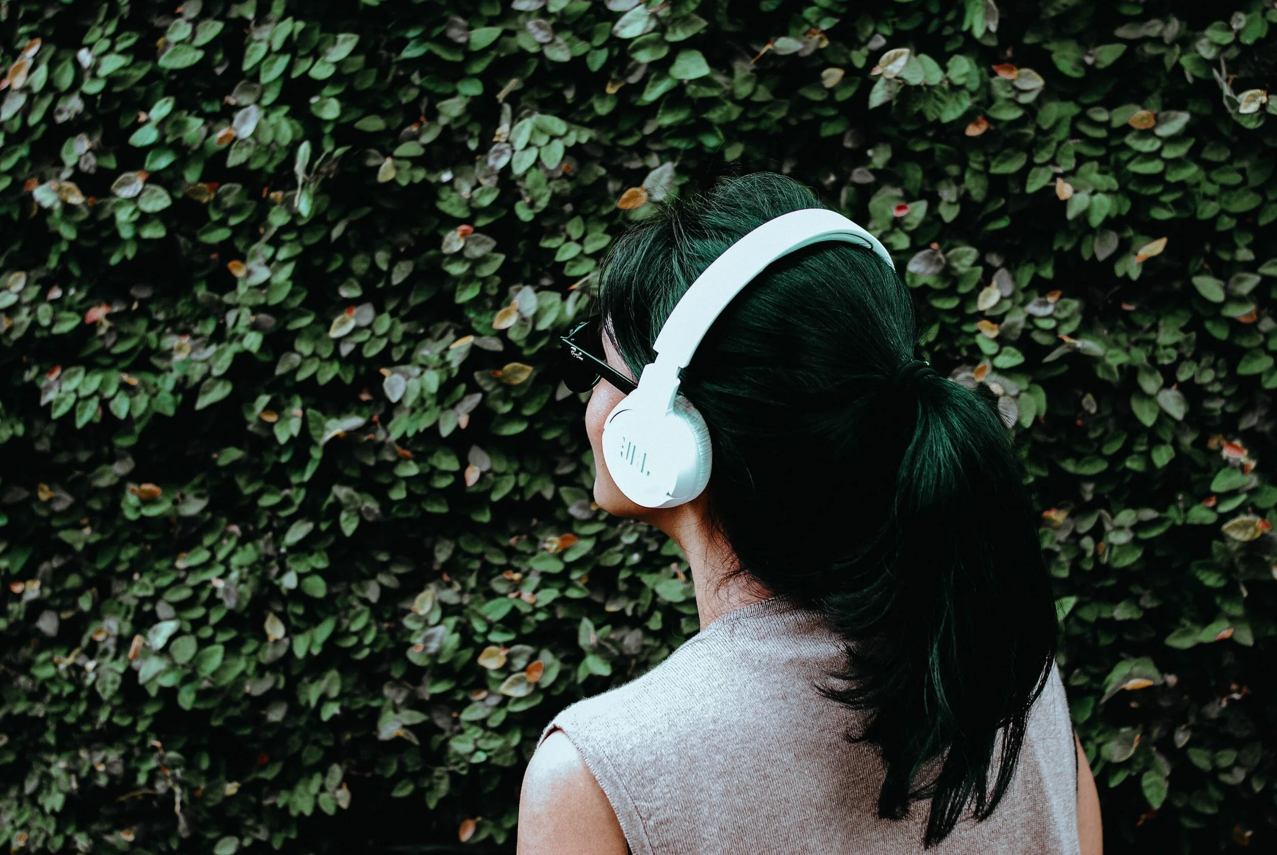 Woman wearing headphones in a calm indoor setting. Many people seeking a therapist in Dallas are looking for support. Counseling Dallas Texas can include tools that support greater regulation. Request a consultation.