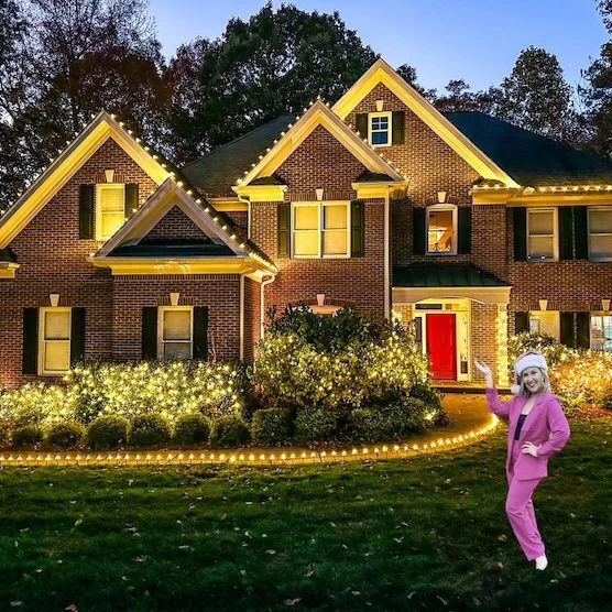 Brick house with christmas lights on roof and bushes