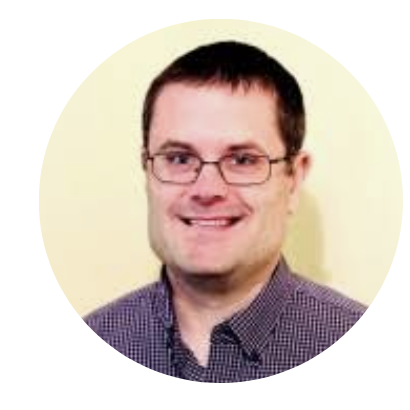 Man wearing glasses and a checkered shirt smiling