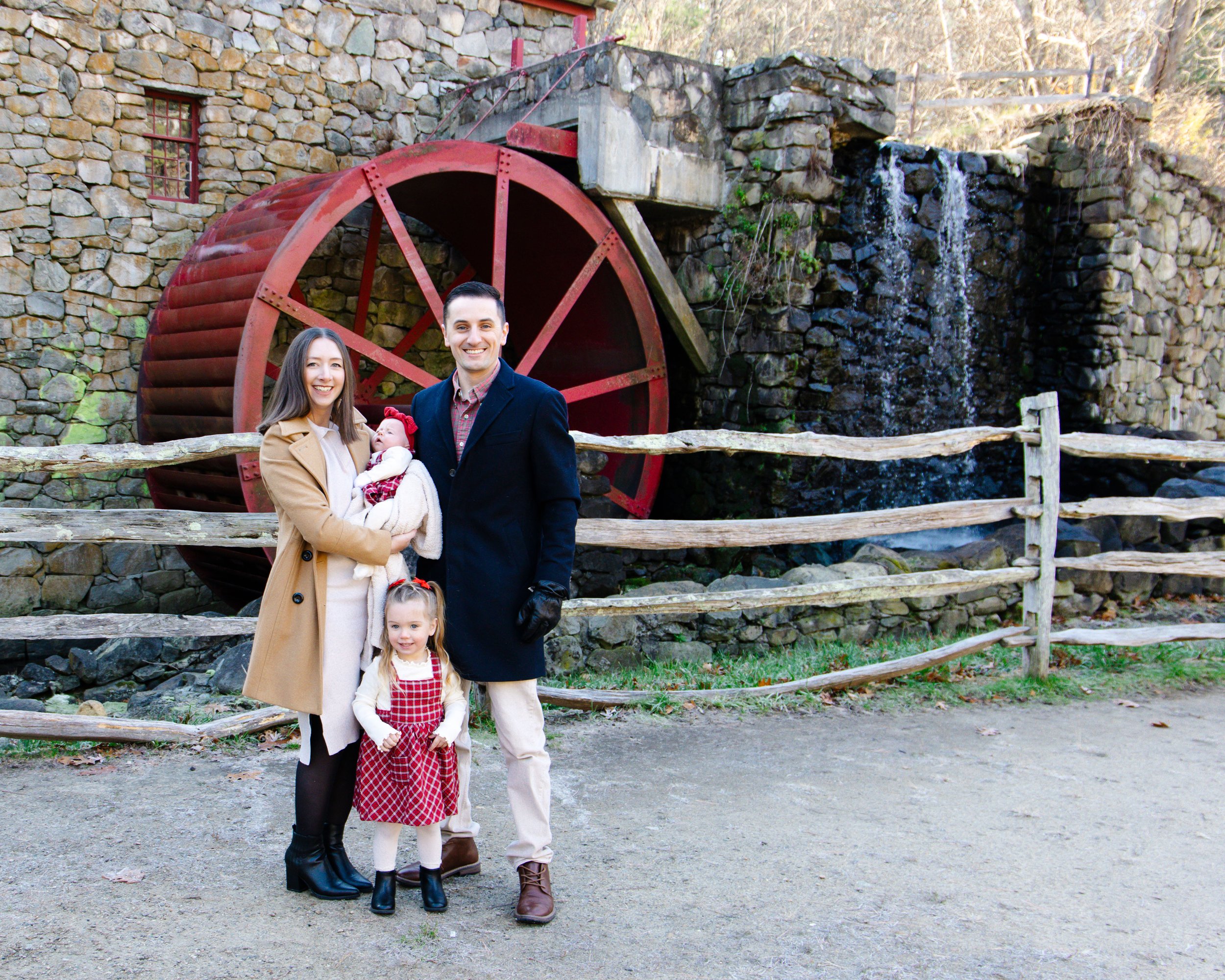 A family of four standing in front of a mill
