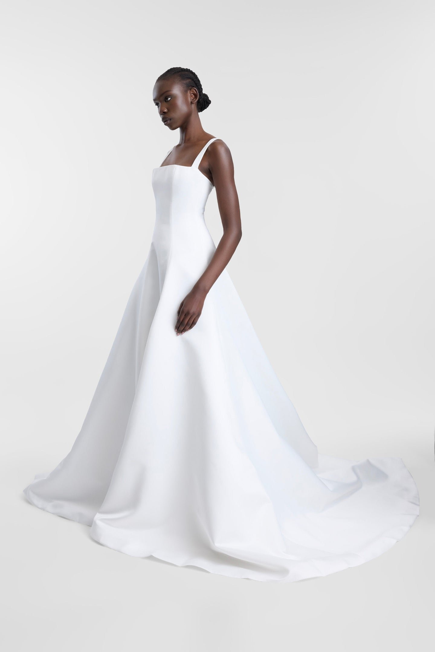 Minimalist moments served via KYHA Bride Holloway. Imagined crafted in bright ivory duchess satin, Holloway is brought to life through its square neckline and soft-but-architectural A-line silhouette . It features a strapped, corseted bodice and skir