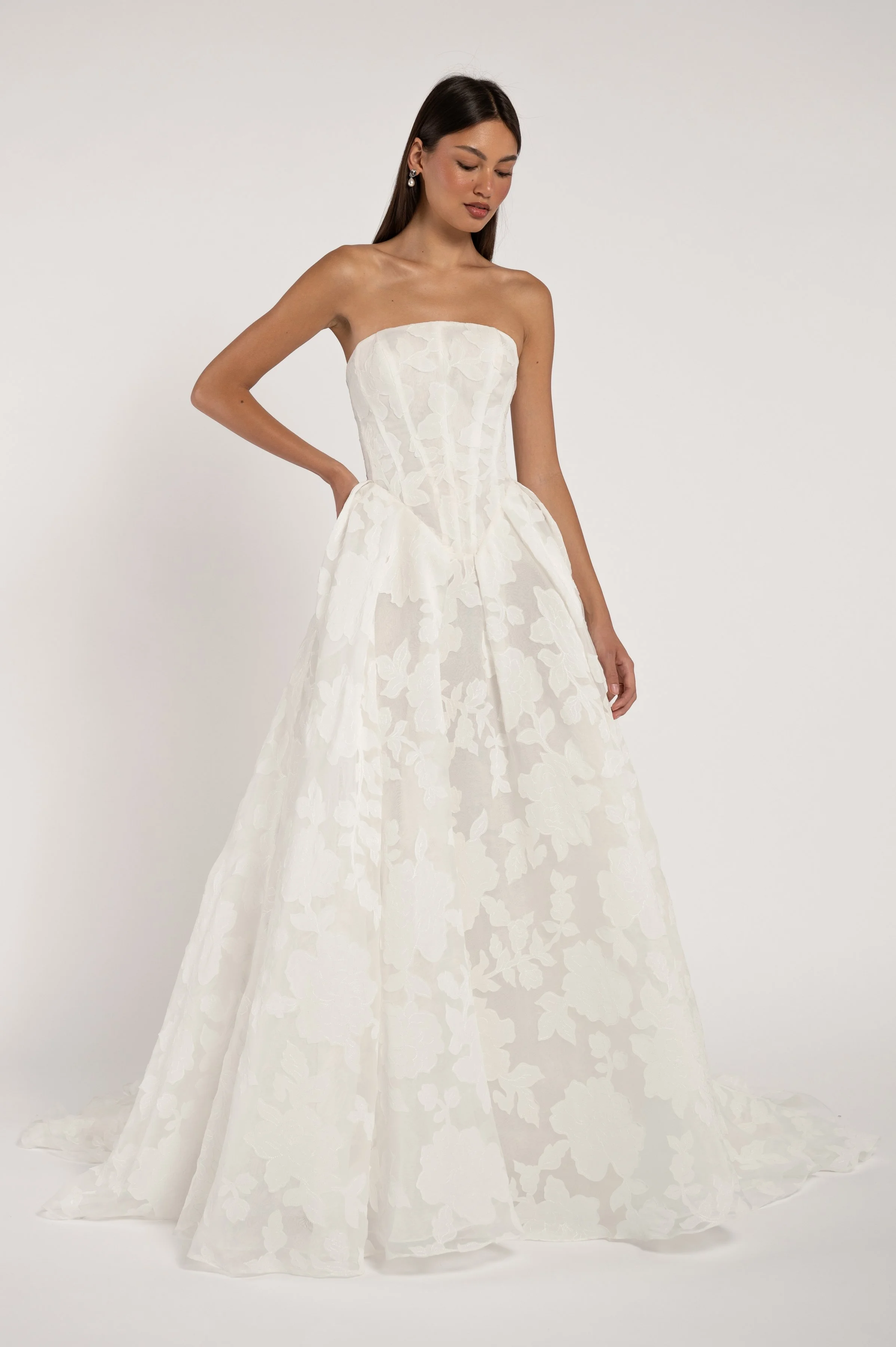 Jenny Yoo The Alva gown marries a modern corset bodice with a dramatically romantic floral motif. The overall effect being one that is strikingly timeless. Available at Halo & Wren