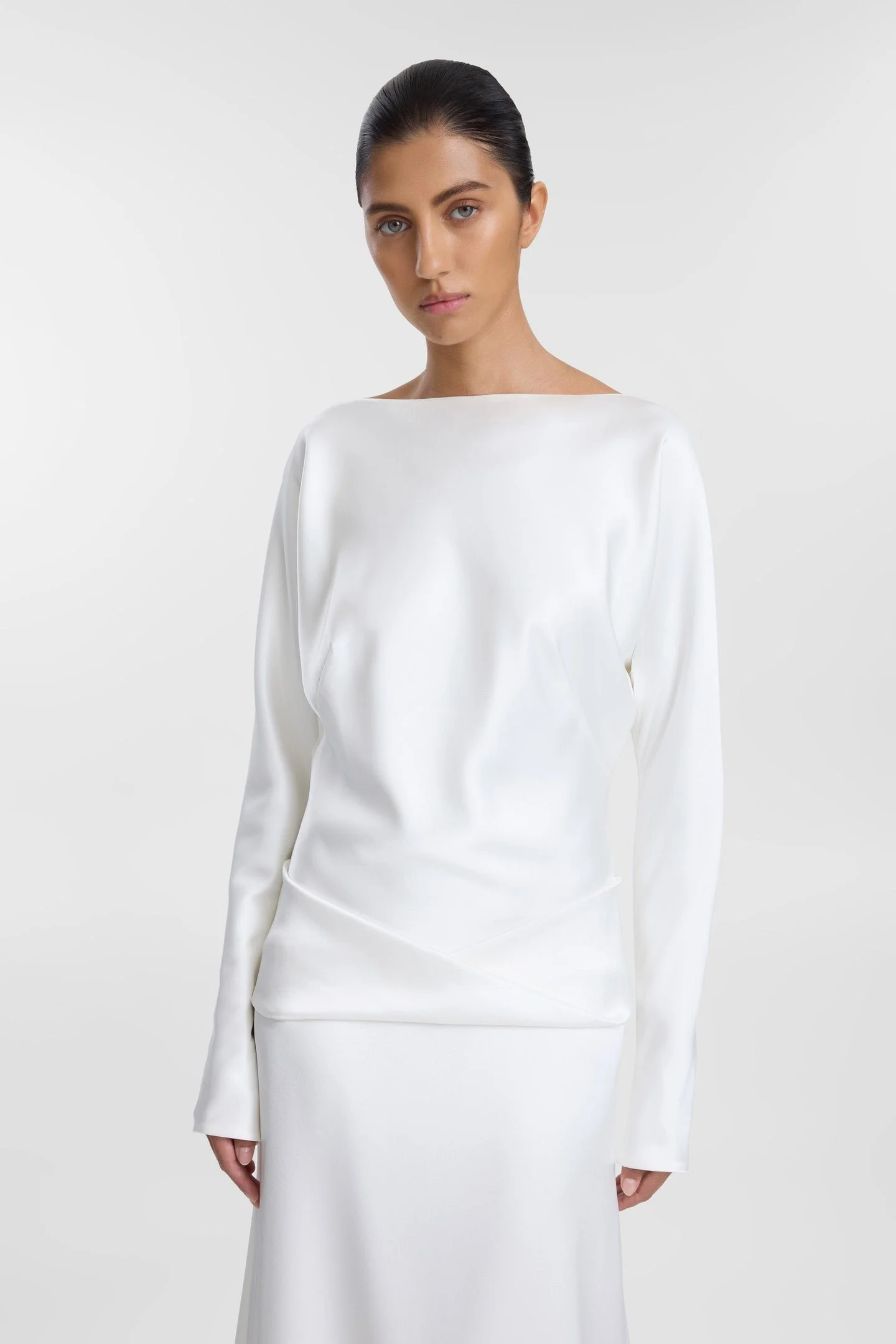 Meet KYHA Bride Lola, spirit of the 70s that will live in your head rent-free. Cut for a slightly oversized fit in luxe double satin, Lola features long batwing sleeves, a twisted sash at the hip, and a skirt with a soft train. The open back adds an 