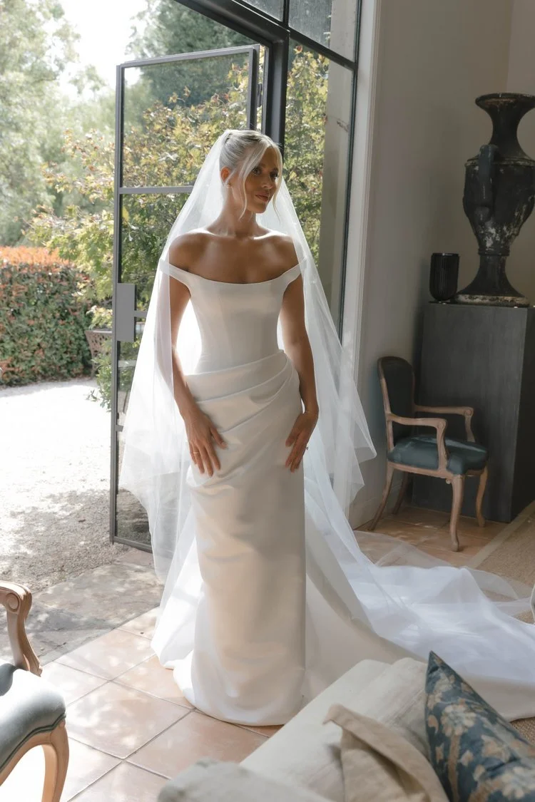KYHA Bride Winton Gown is a modern bridal statement defined by clean lines and confident structure. featuring a sleek silhouette that skims the body, the Winton balances minimalist design with considered detailing for a refined, fashion-forward look.