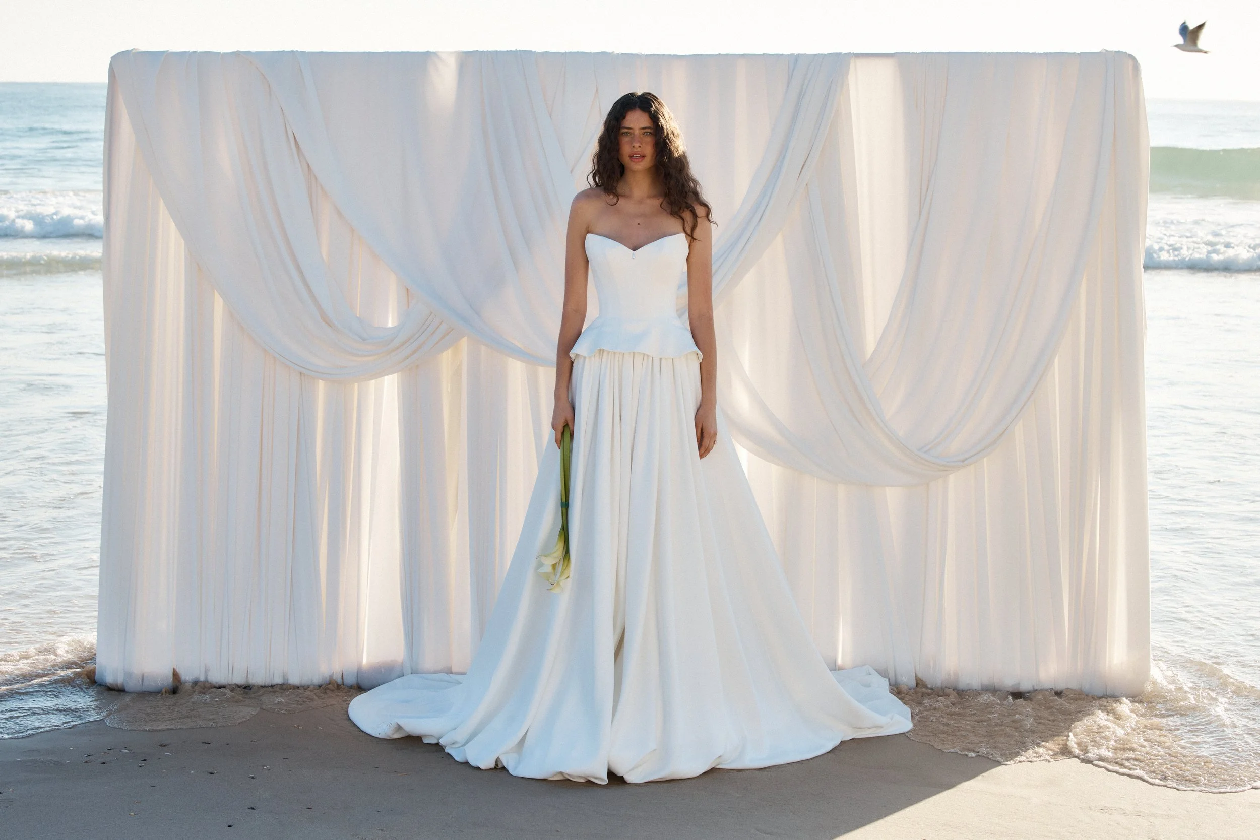 Tanner by MWL, made from our luxurious Avery Satin, the skirt flows beautifully and is finished with a bagged out bubble hem, adding subtle volume and a touch of drama. Inside the bodice, interfacing provides extra support, ensuring a secure and eleg